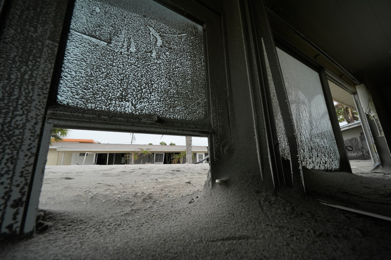 Several feet of sand fills condos at YCA Vacation Rentals, following the passage of Hurricane Milton, in Venice, Fla., Friday, Oct. 11, 2024. (AP Photo/Rebecca Blackwell)