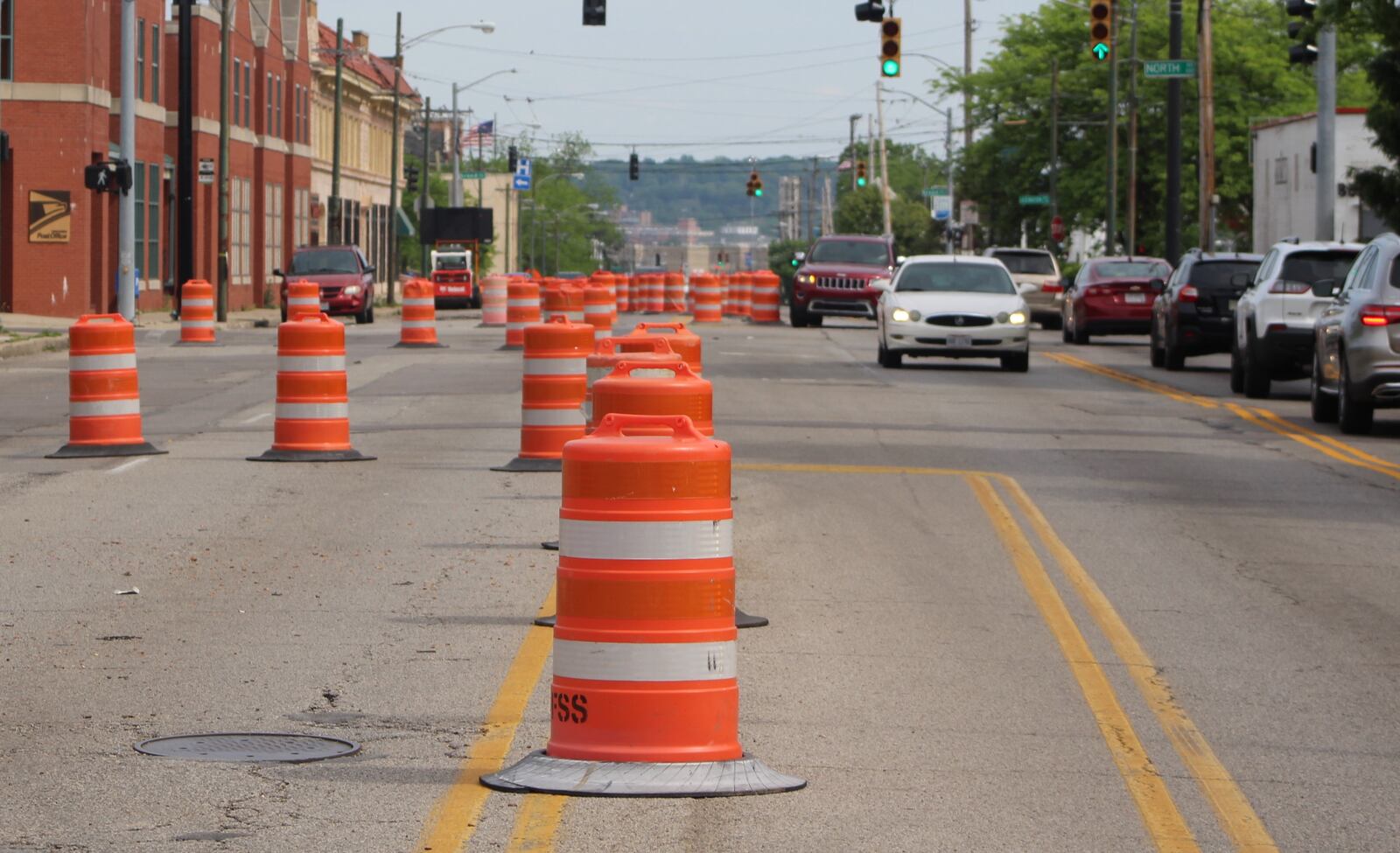 Cars drive by orange barrels set up as Salem Avenue begins to be reconstructed. CORNELIUS FROLIK / STAFF