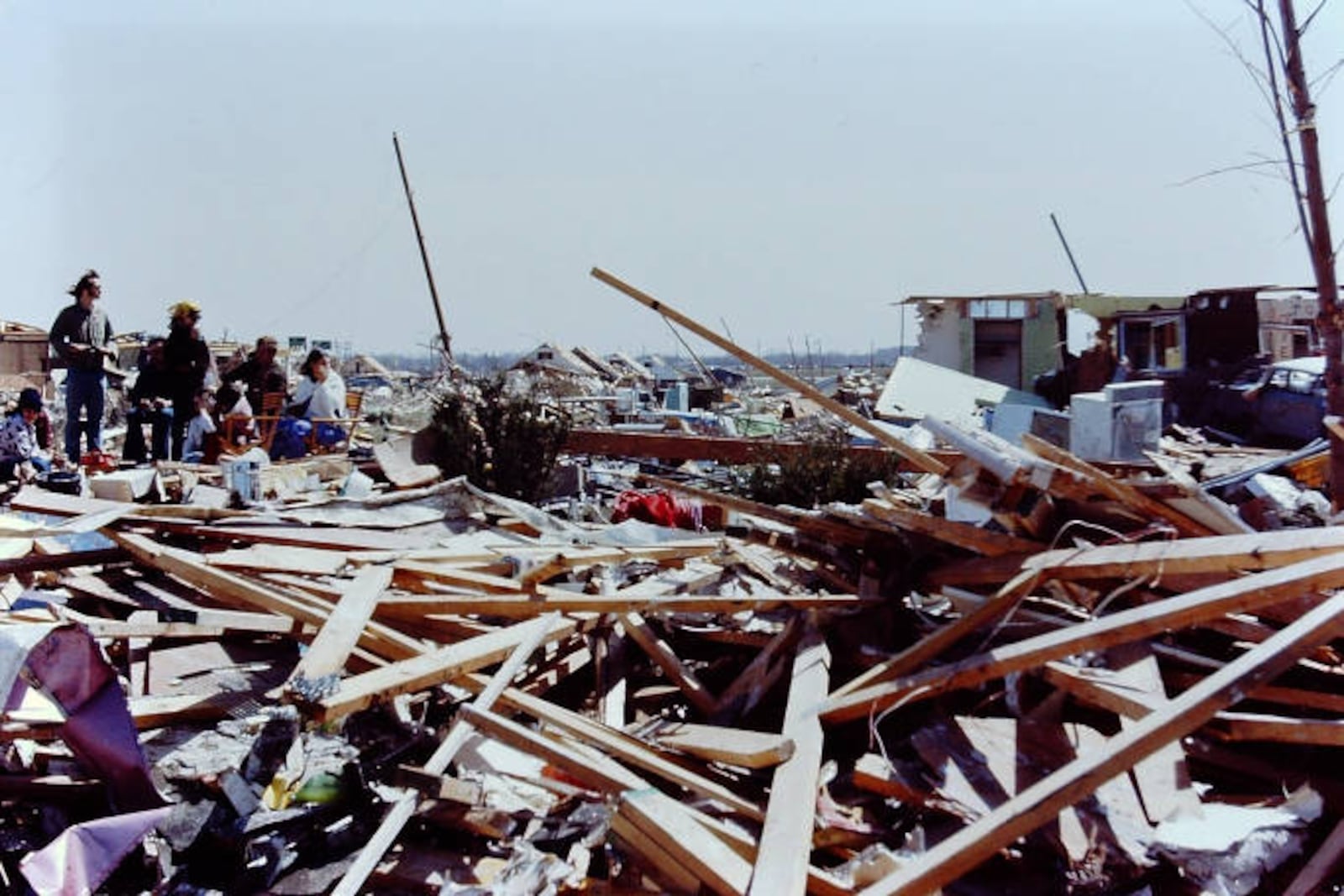 A group of survivors stands in the rubble of backyards between Texas Drive and Commonwealth Drive. CONTRIBUTED