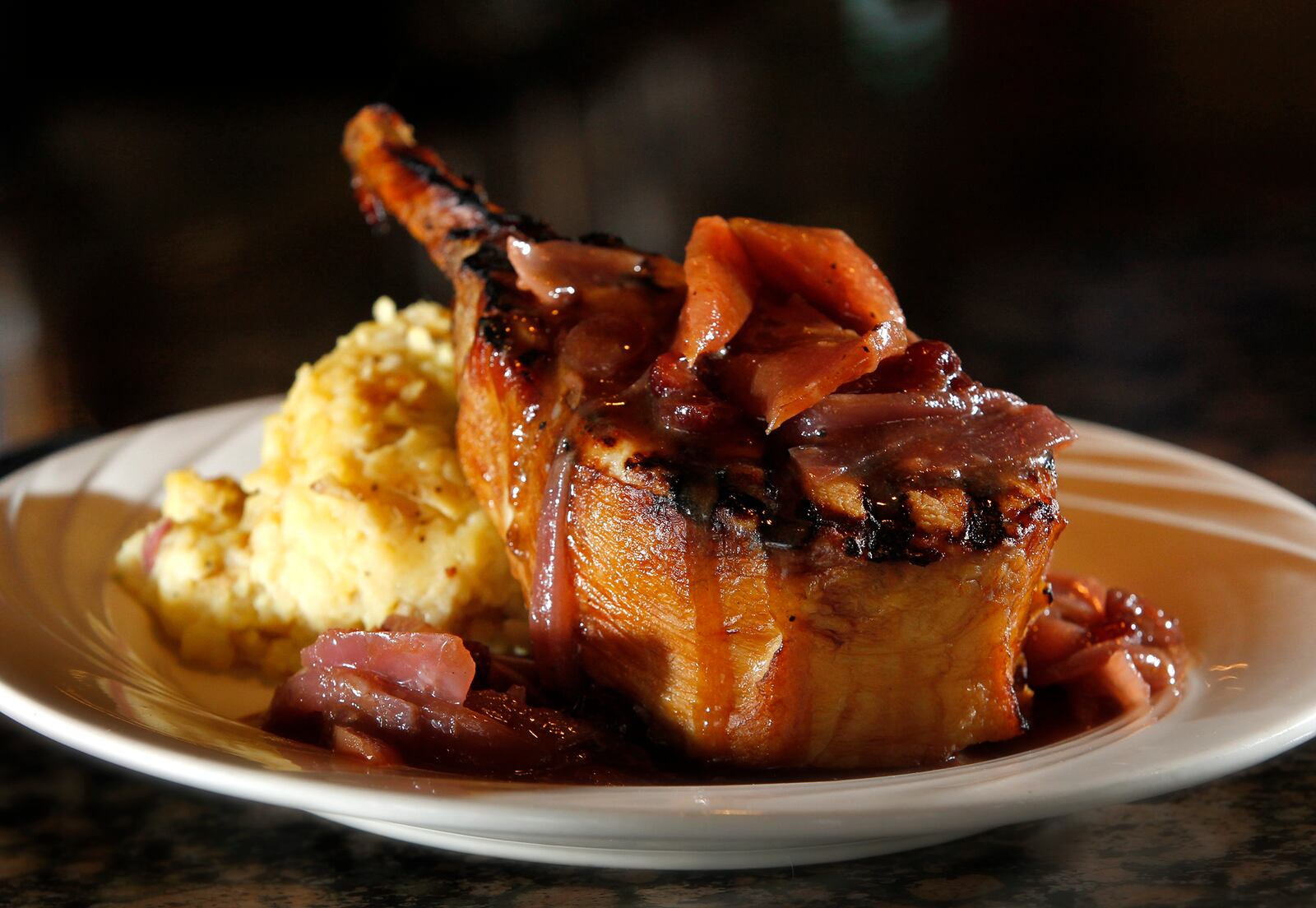 The Amber Rose Restaurant and Catering is a Dayton institution specializing in homemade Eastern European cuisine. On the menu is a bone-in smoked porkchop topped with cinnamon apple demi-glaze and served with mashed potatoes. LISA POWELL / STAFF