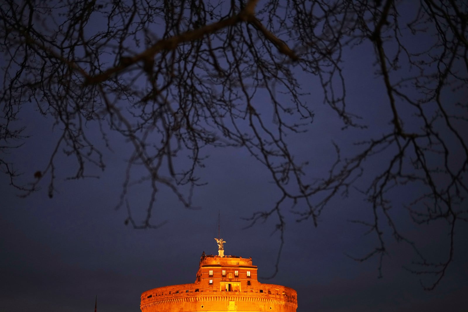 The Sant'Angelo castle is illuminated as the sun sets in Rome, Friday, March 7, 2025. (AP Photo/Francisco Seco)