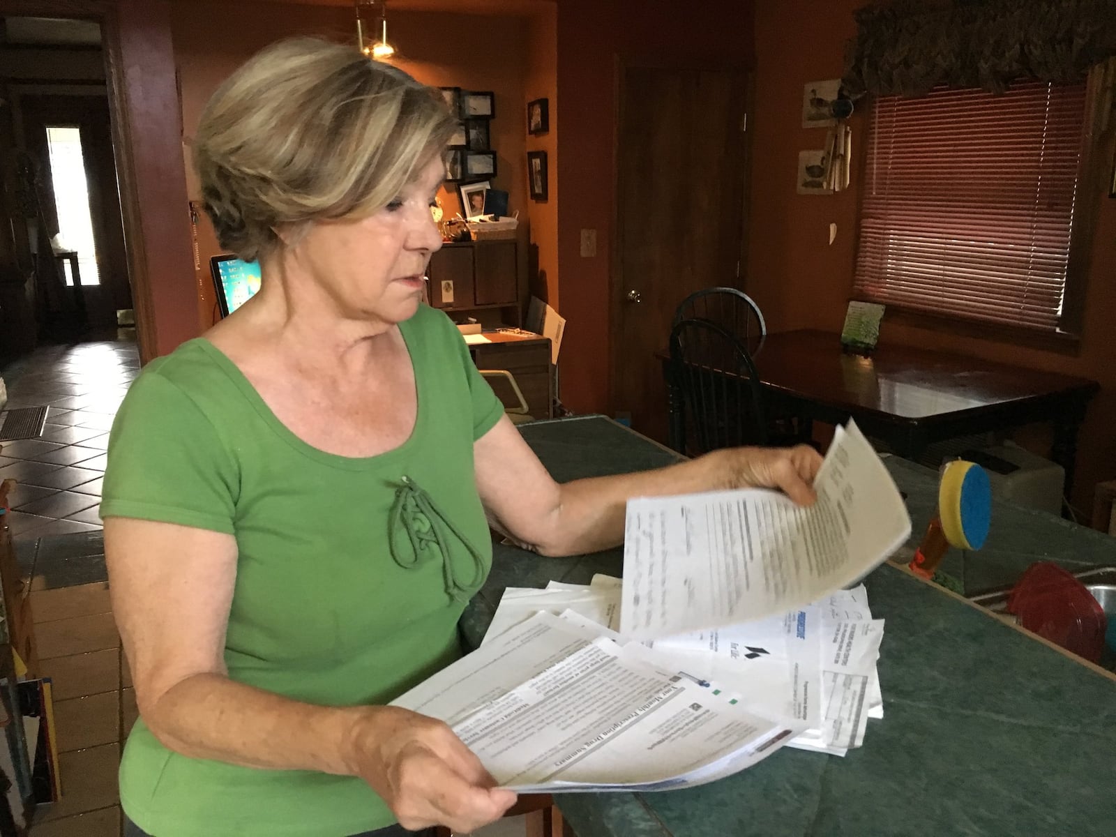 Paula Humphrey displays some of the denial letters she received from the Ohio Victims of Crime Compensation Program after she was brutally assaulted in her Dayton home. Humphrey says she faced insurmountable bureaucracy in the program until she learned she could get an attorney at no charge.