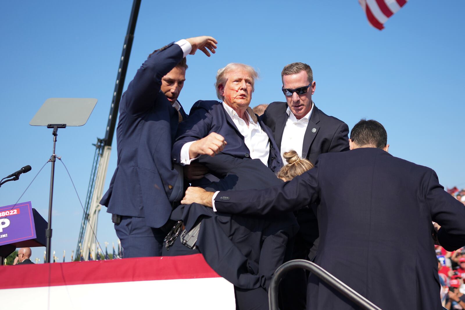 
                        Former President Donald Trump is surrounded by Secret Service agents at a campaign rally in Butler, Pa, on Saturday, July, 13, 2024. Trump was rushed off stage at rally after sounds like shots; the former president was escorted into his motorcade at his rally in Butler, Pa., a rural town about an hour north of Pittsburgh. (Doug Mills/The New York Times)
                      