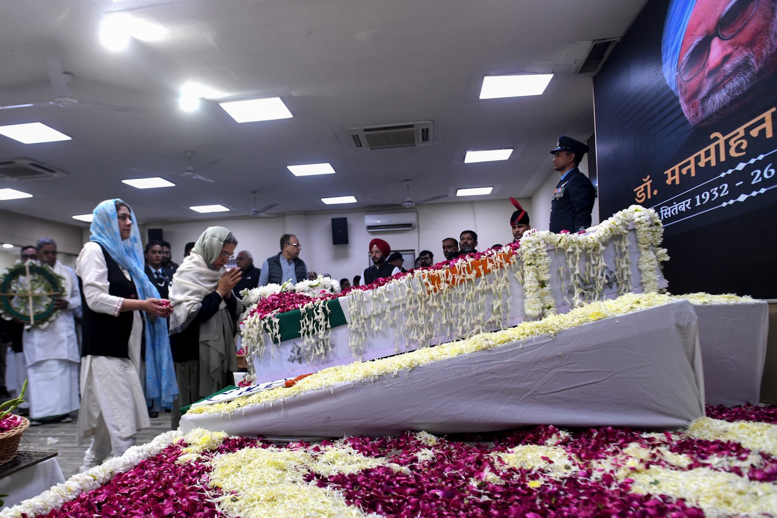 Gursharan Kaur, second left, wife of former Indian Prime Minister Manmohan Singh, prays next to the casket of her late husband to pay her tributes at the Congress party headquarters in New Delhi, India, Saturday, Dec. 28, 2024. (AP Photo)