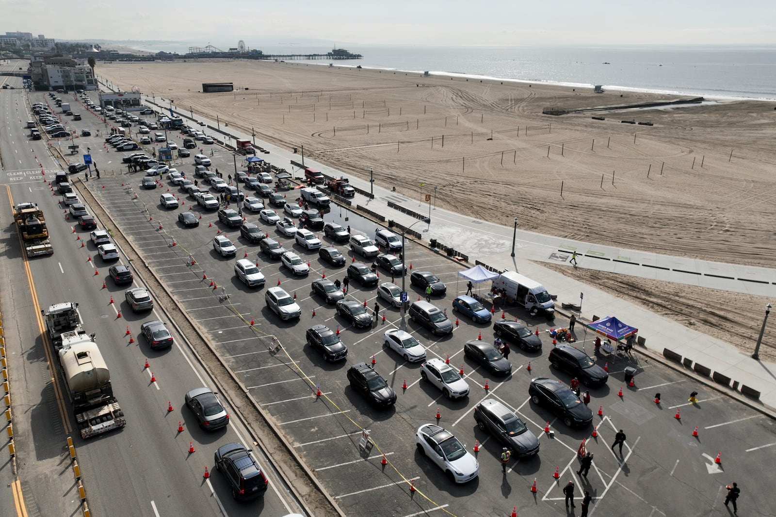 Motorists form a queue in a parking lot and along Pacific Coast Highway waiting to enter the Palisades Fire zone Tuesday, Jan. 28, 2025 in Santa Monica, Calif. (AP Photo/Jae C. Hong)