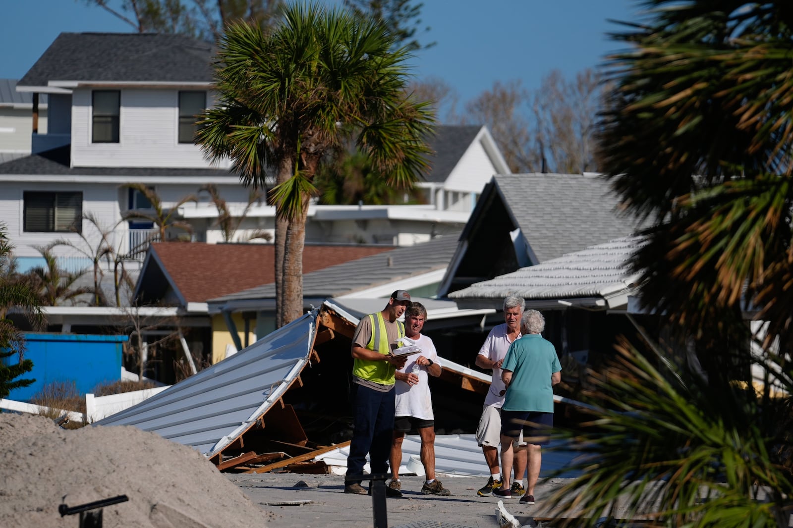 FILE - Property owners speak with an official as they process the damage to their homes and community following Hurricane Milton, on Manasota Key, in Englewood, Fla., Sunday, Oct. 13, 2024. (AP Photo/Rebecca Blackwell)