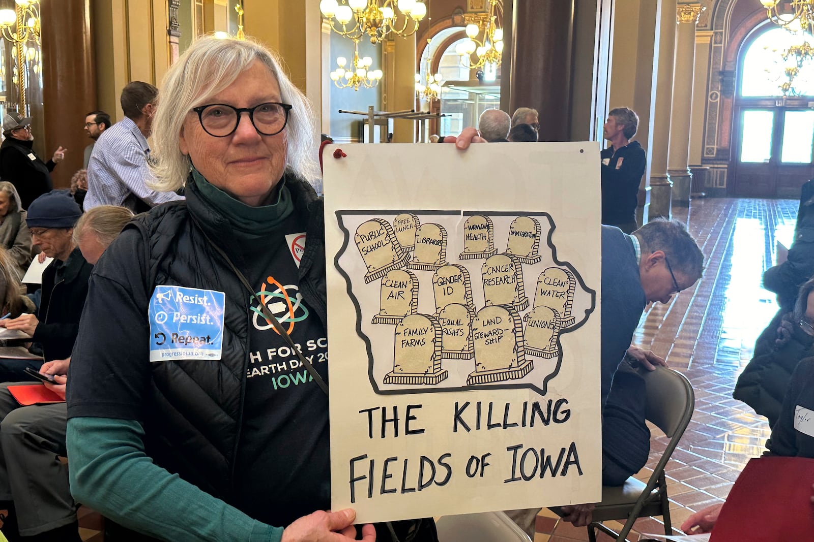 Jane Meggers holds up a sign she brought to a Feb. 10, 2025, protest in Des Moines, Iowa, to oppose a bill that would protect pesticide companies from lawsuits that claim its popular weedkiller causes cancer. (AP Photo/Hannah Fingerhut)