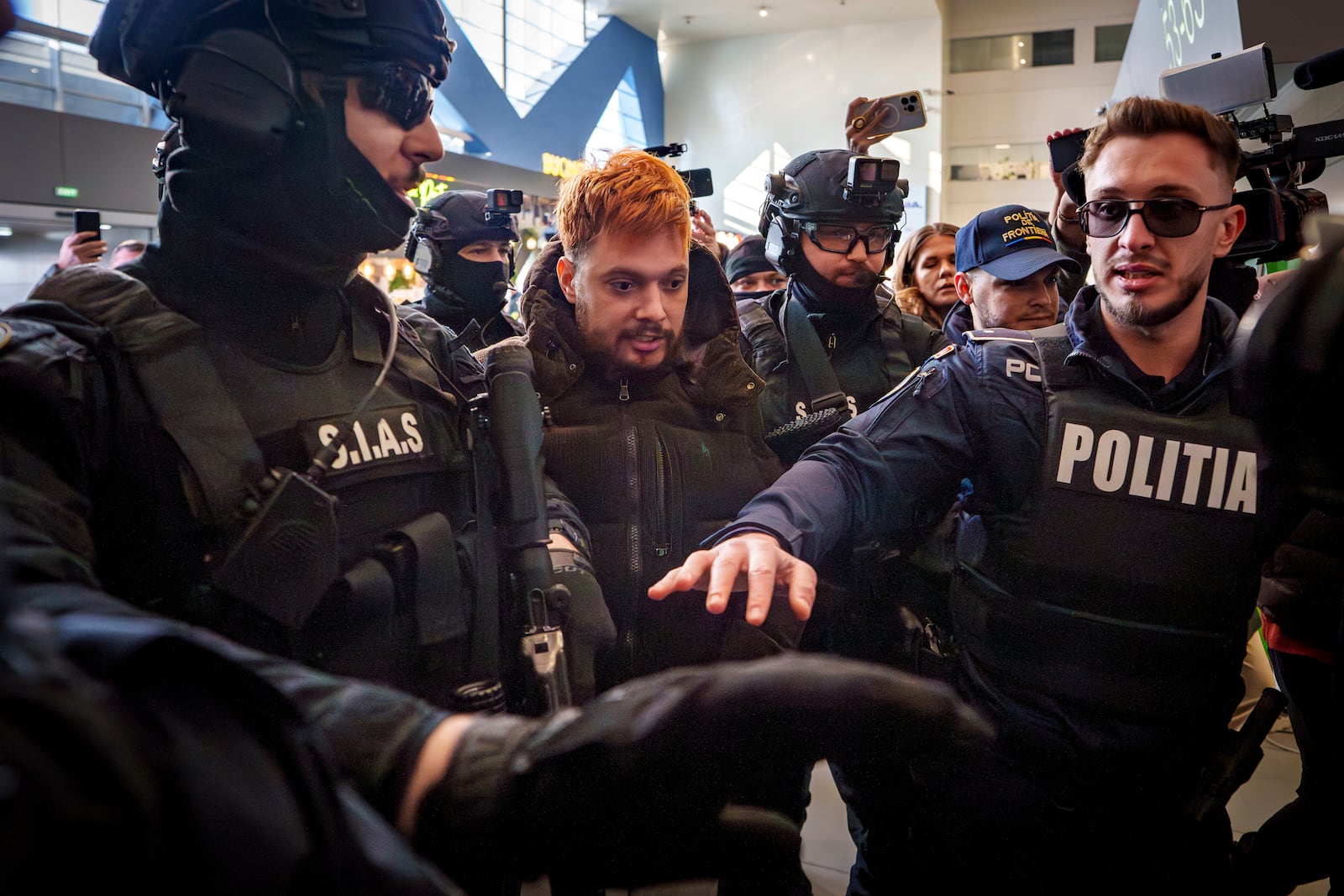 Mohamed Amra, nicknamed ''The Fly", is escorted by armed police officers at the Henri Coanda international airport in Otopeni, Romania, Tuesday, Feb. 25, 2025, before being extradited to France. (AP Photo/Vadim Ghirda)