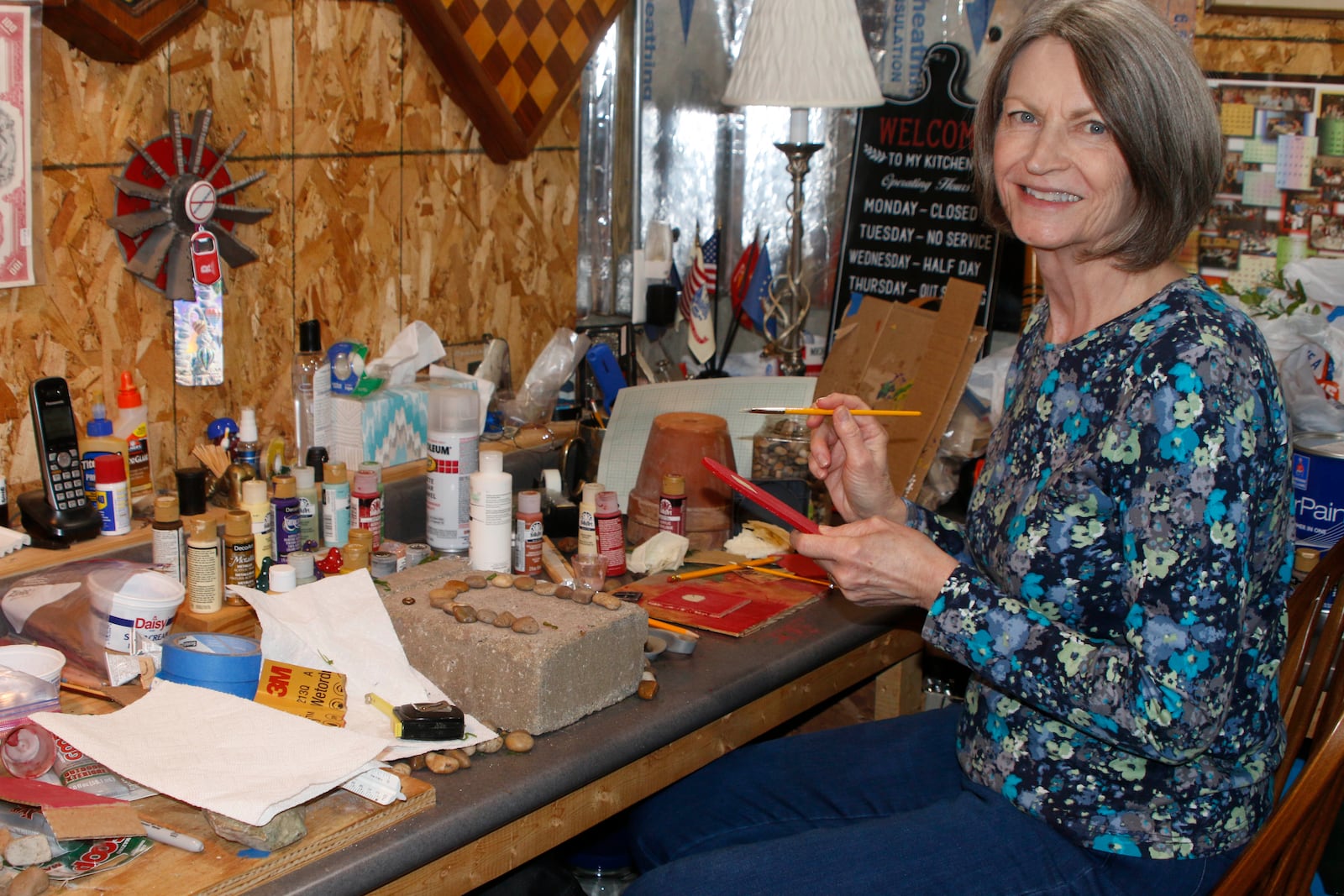 Kathy Anderson of Butler Twp. works on a house for the Aullwood Faerie House Exhibit, Earth Elements, which is on display through Labor Day. DAVE HILL/COURTSEY PHOTO