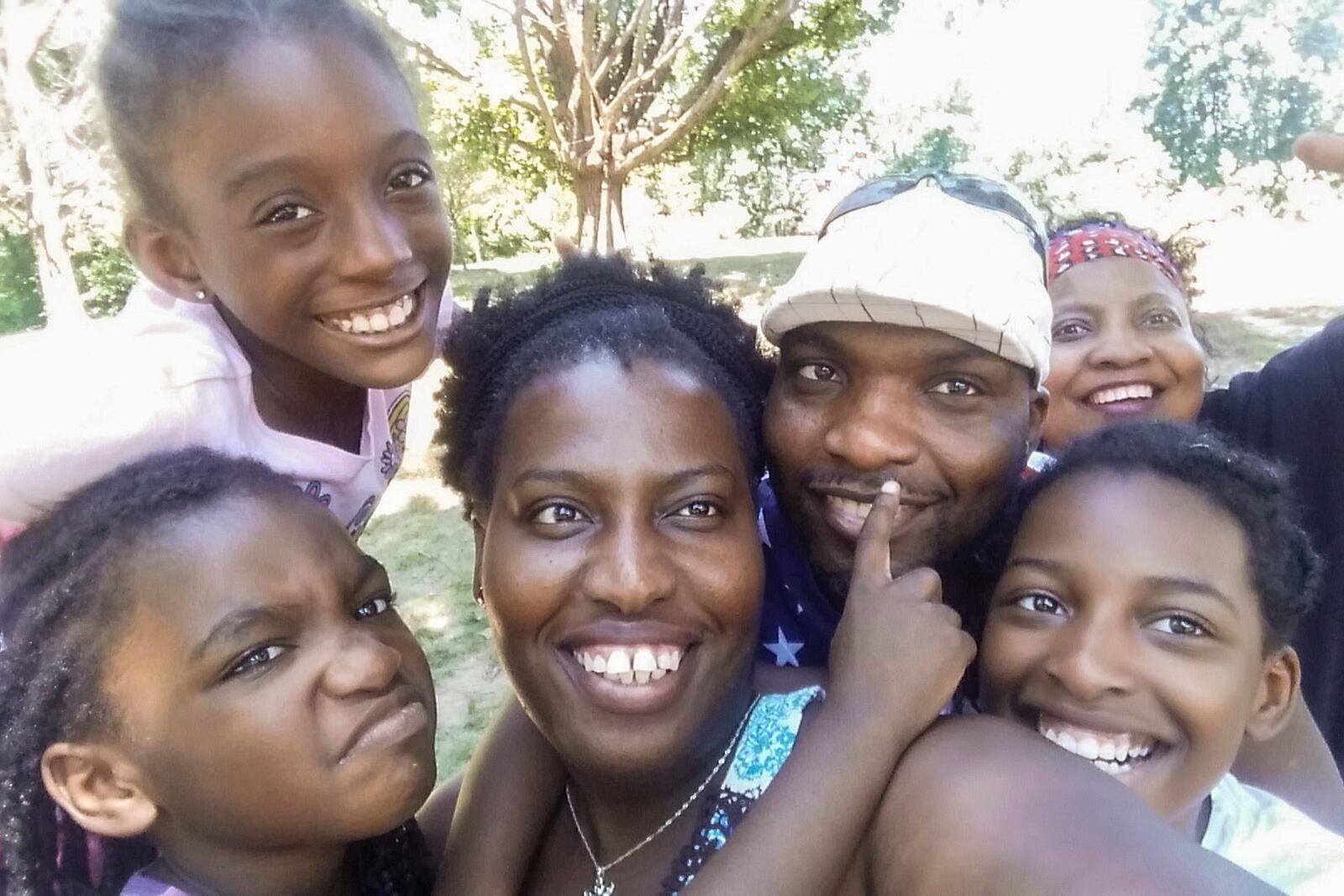 In this photo provided by Sharline Volcy, Volcy, her husband Ronald Donat, their two daughters and two other relatives pose for a photo at a 2016 family picnic in West Orange, N.J. (Sharline Volcy via AP)