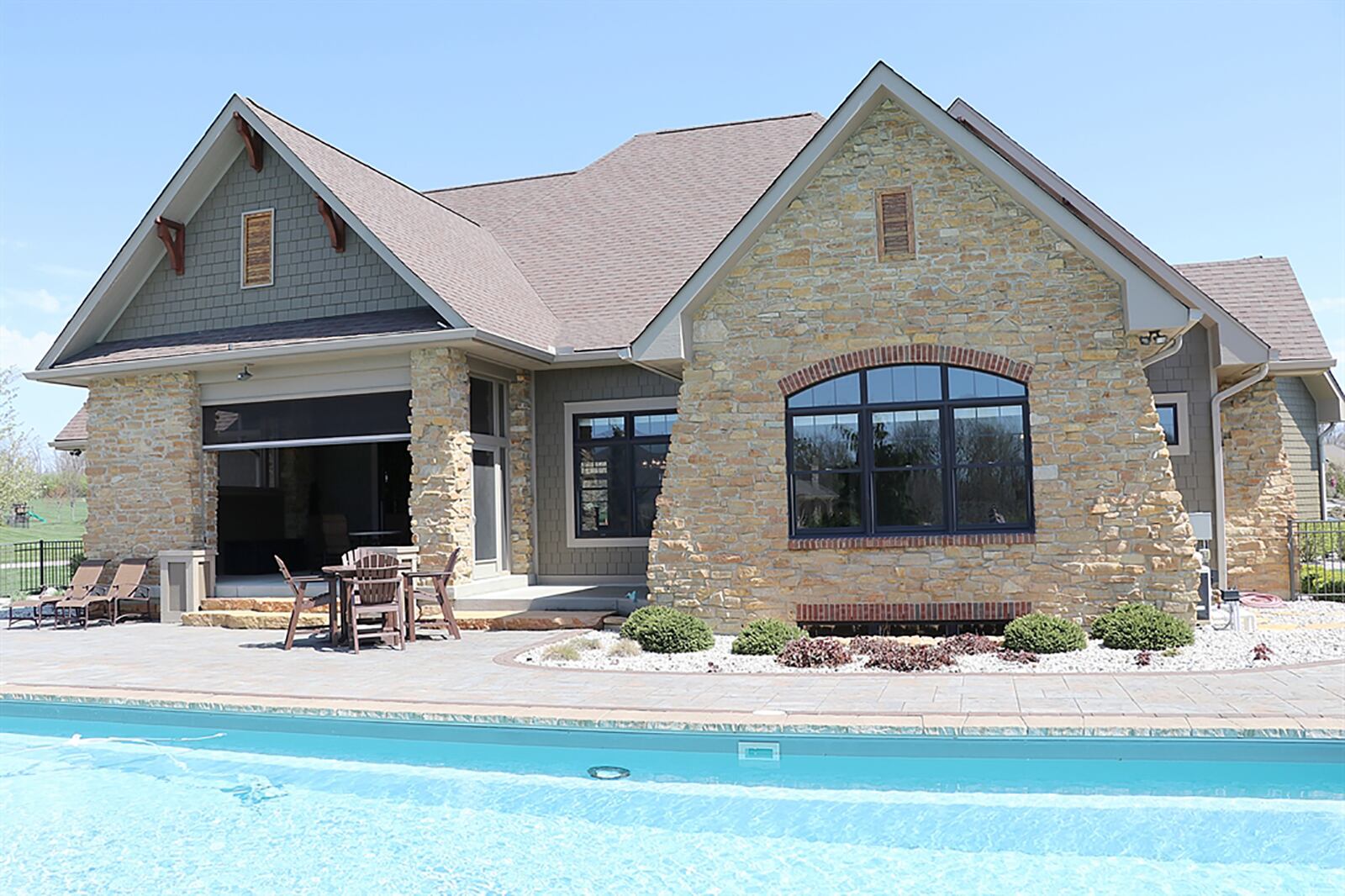 The home sits diagonally on the property with evergreens accenting the outdoor living space that includes a salt-water, in-ground swimming pool with 3 waterfalls. Paver-stone surrounds the pool and stone fire pit and pebble-rocks highlight the garden beds. CONTRIBUTED PHOTO BY KATHY TYLER