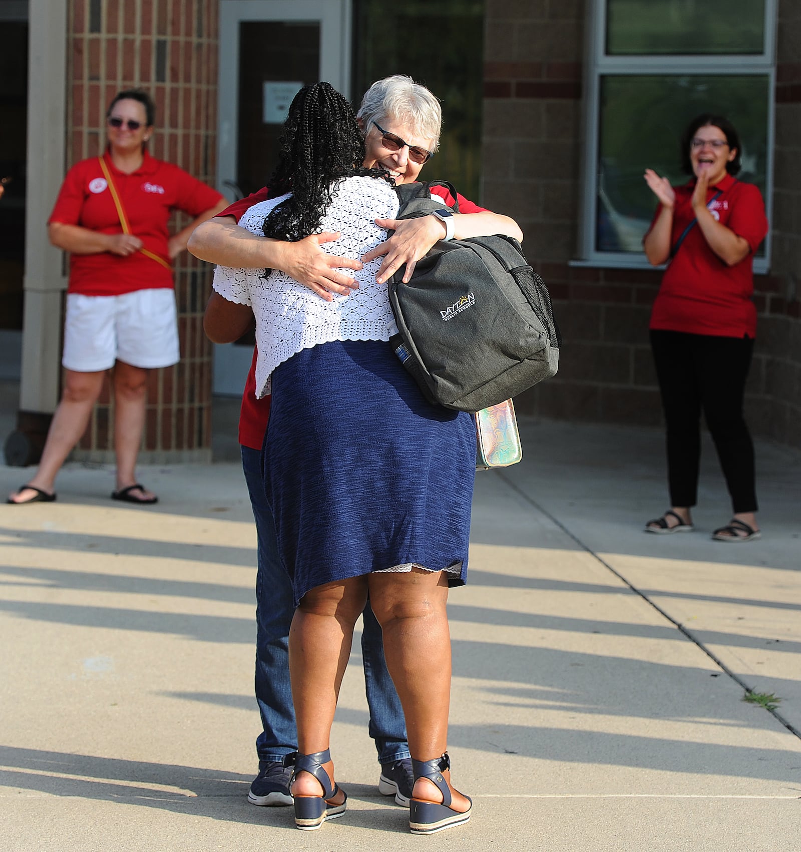 Theresa Green, a Dayton teacher for 36 years hugs new teacher Janeen Early during the Dayton teachers union members clap in for first year teachers Thursday, Aug. 3, 2023 at Thurgood Marshall High School. MARSHALL GORBY\STAFF