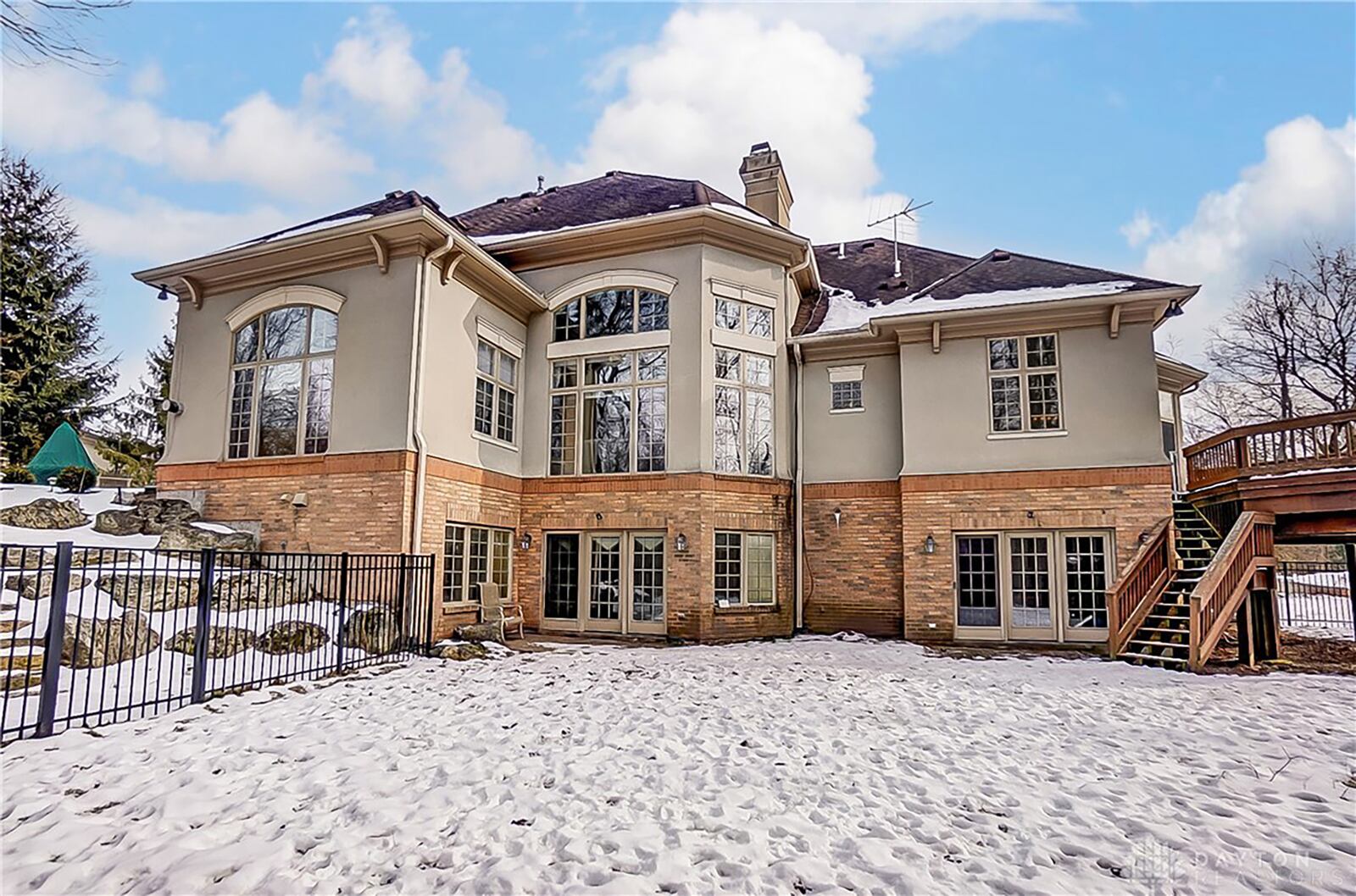 The rear of the home is partially fenced and has a lower level paver patio and upper level deck.