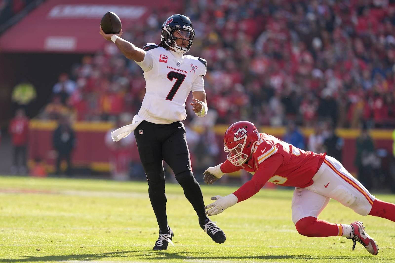 Houston Texans quarterback C.J. Stroud (7) throws a touchdown pass under pressure from Kansas City Chiefs defensive end George Karlaftis during the first half of an NFL football game Saturday, Dec. 21, 2024, in Kansas City, Mo. (AP Photo/Charlie Riedel)1