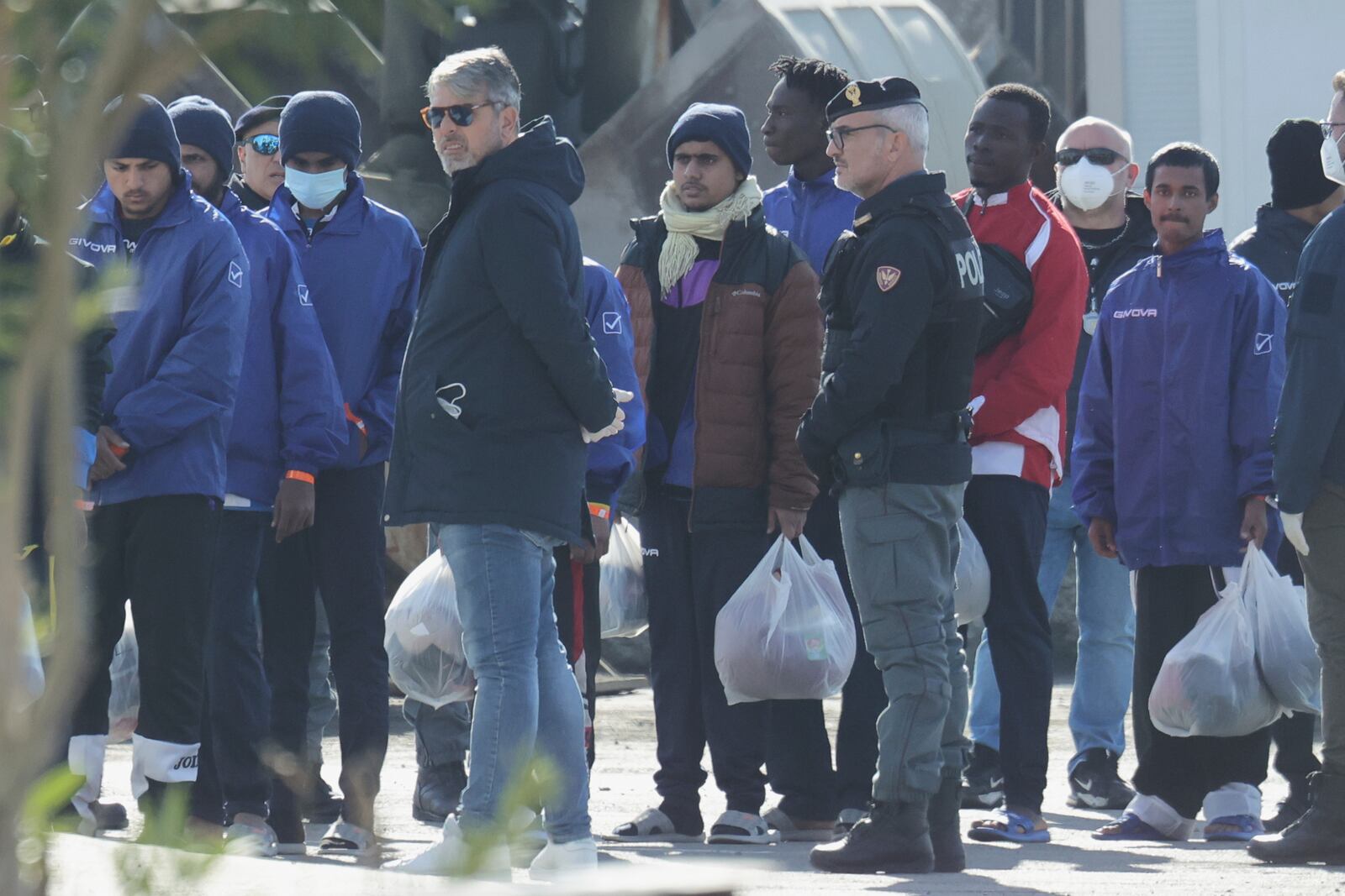 Migrants follow the authorities after their arrival, as Italy sent 49 people to Albania for processing following earlier court rejections to Albania, in the port of Shengjin, northwestern Albania, Tuesday, Jan. 28, 2025. (AP Photo/Vlasov Sulaj)