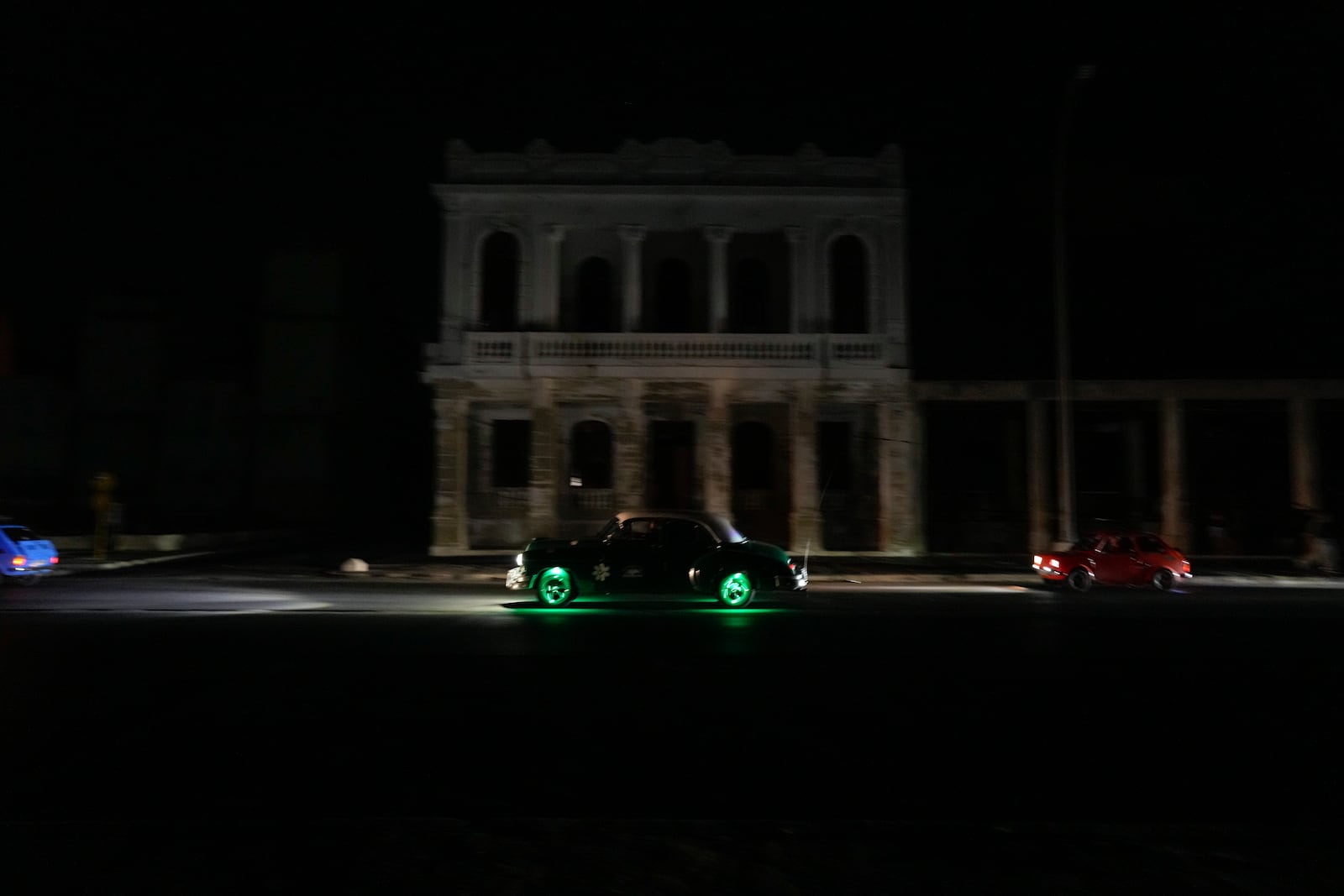 A classic American car is driven along the Malecon during a general blackout in Havana, Saturday, March 15, 2025. (AP Photo/Ramon Espinosa)