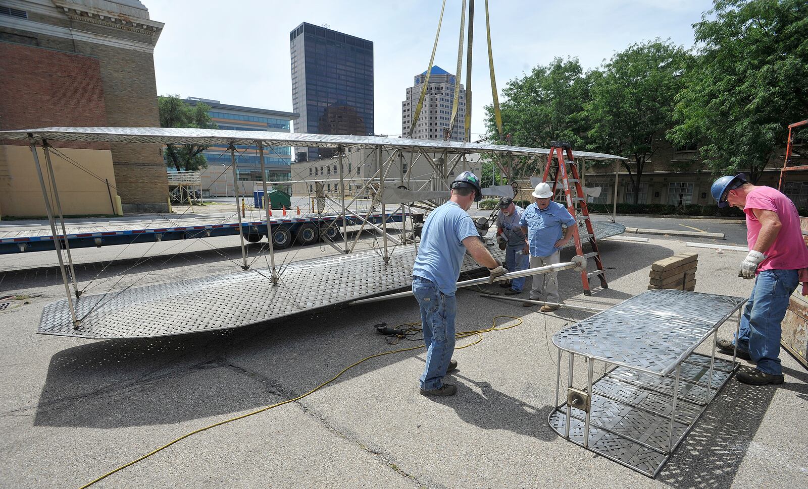 Workers for Schumacher Crane moved the Wright Brothers sculpture that has been on Monument Avenue across from Riverscape Metro Park for nearly two decades. The sculpture was moved to allow for redevelopment of the Monument Avenue site. MARSHALL GORBY/STAFF