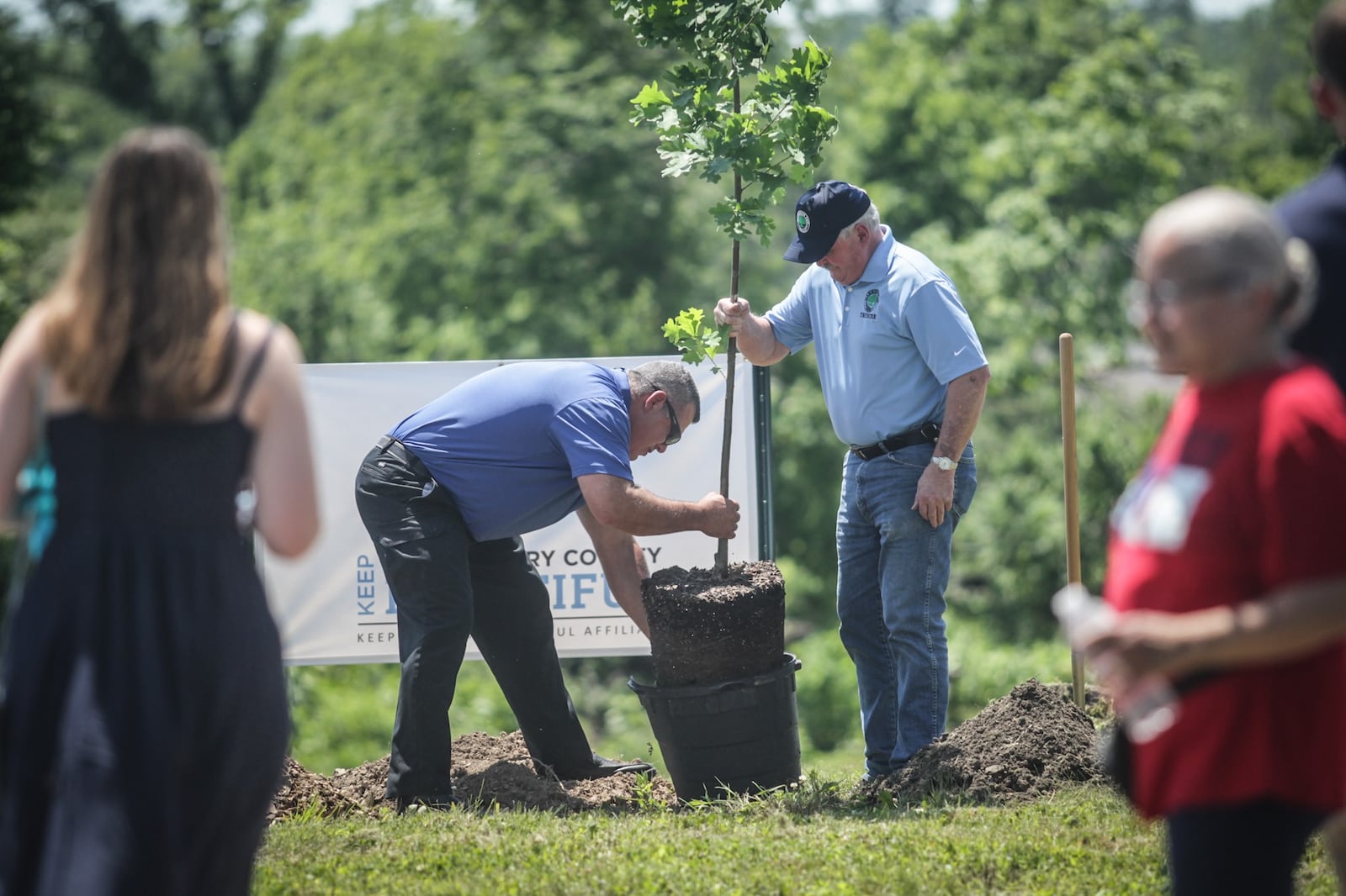 From left, Harrison Twp. service director Merle Cyphers and Harrison Twp. Trustee Charlie Waldron plant a maple tree in June 2021 at Sinclair Park. The township held a tree planting kickoff to begin restoring the tree canopy that the park lost to the Memorial Day tornadoes in 2019. JIM NOELKER/STAFF