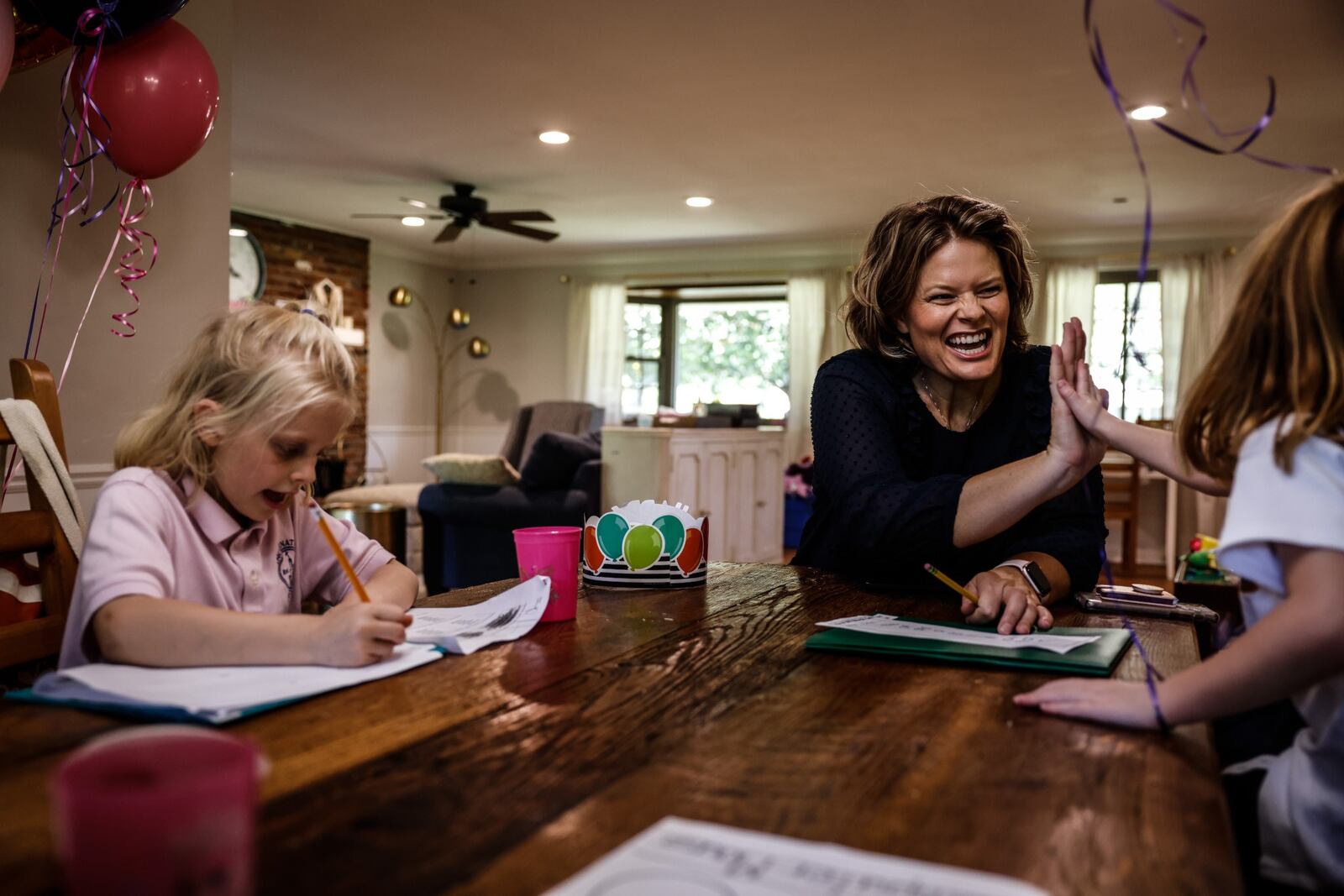 Kate Vriner and her daughters Rita, left, and Evelyn go over homework after school. The Centerville family has been juggling child care and work during the pandemic. JIM NOELKER/STAFF