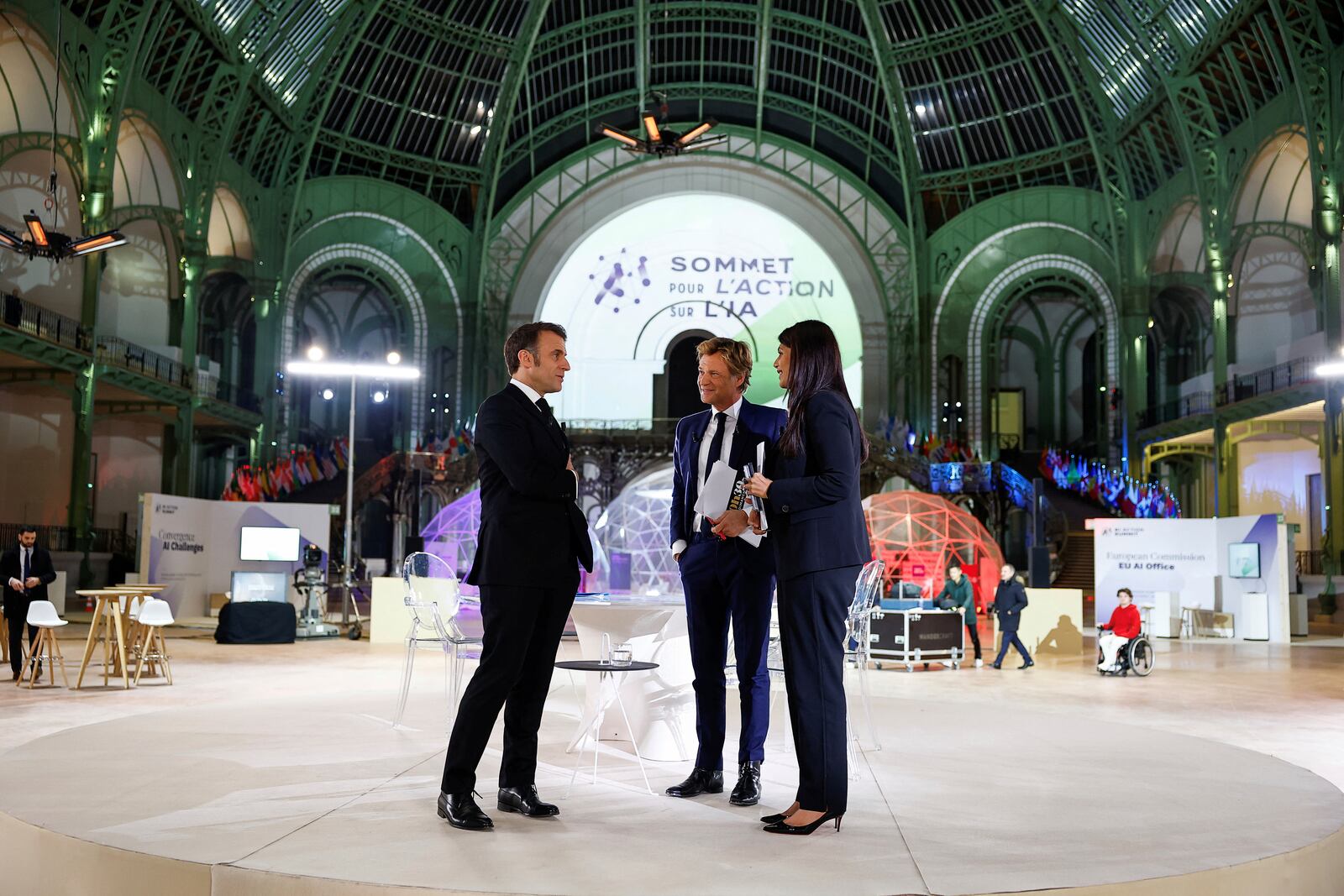 French President Emmanuel Macron, left, attends an interview with French Journalist Laurent Delahousse and Indian Journalist Palki Sharma Upadhyay, on national television, ahead of the Artificial Intelligence Action Summit at the Grand Palais in Paris, Sunday, Feb. 9, 2025. (Gonzalo Fuentes, Pool Photo via AP)