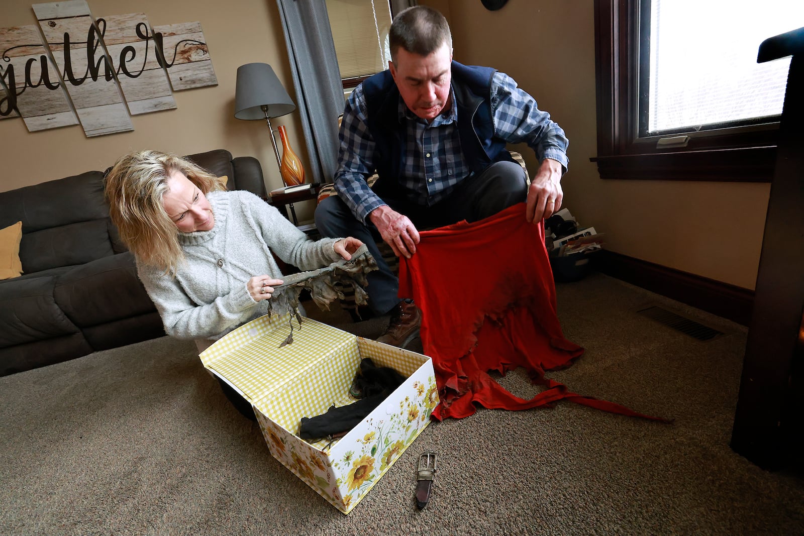 Kevin Pleiman and his wife, Shelly, look over the clothing Kevin was wearing when when he was caught in an explosion and burned over 70% of his body last December.  BILL LACKEY/STAFF