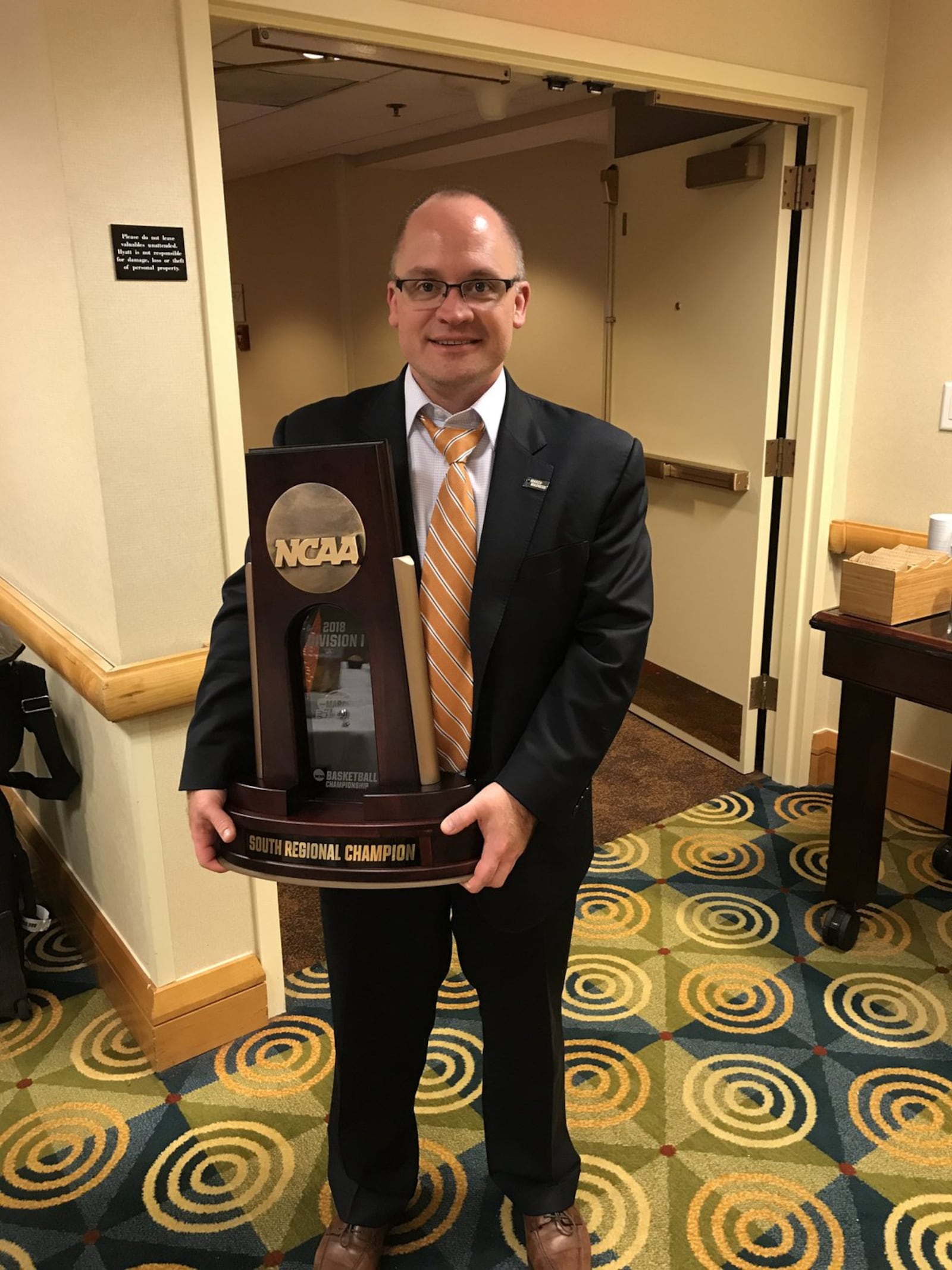 Loyola sports information director Bill Behrns holds the South Regional championship trophy after a victory against Kansas State on Saturday, March 24, 2018, in Atlanta, Ga. Steve Woltmann/Loyola Athletics