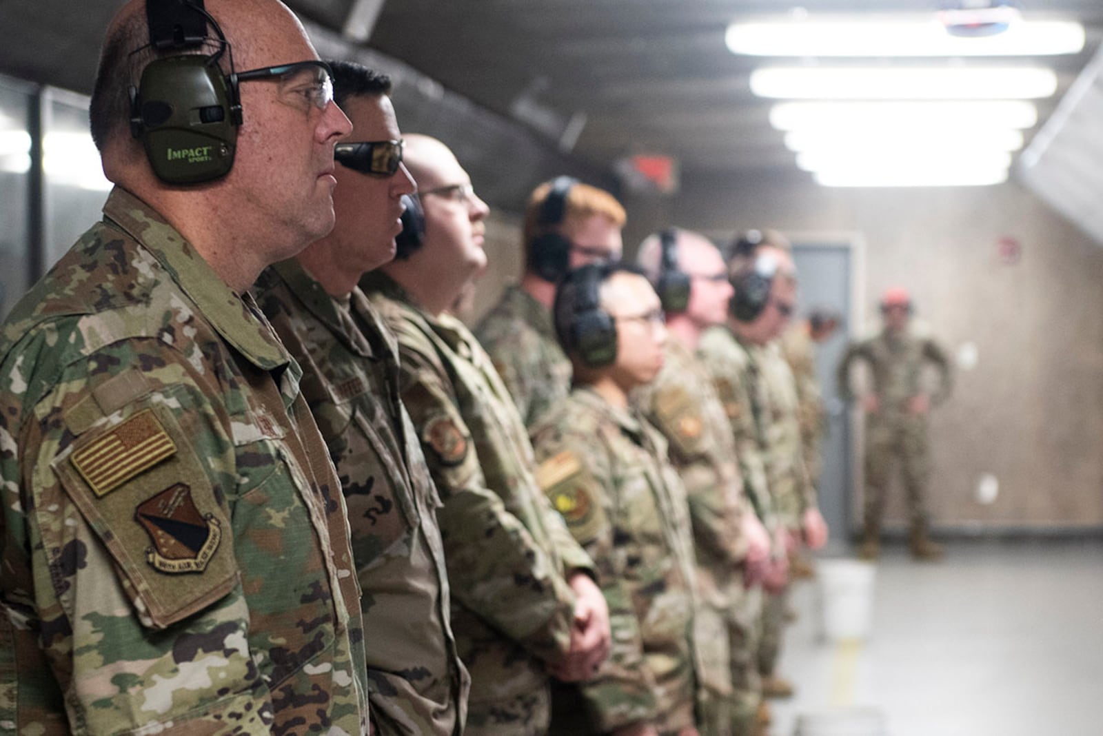 Col. Patrick Miller, 88th Air Base Wing and installation commander, Chief Master Sgt. Jason Shaffer, 88 ABW command chief, and other participants watch as 88th Security Forces combat arms instructors score their targets during the M18 9mm pistol Excellence in Competition shooting event held as part of Police Week at Wright-Patterson Air Force Base. U.S. AIR FORCE PHOTO/WESLEY FARNSWORTH