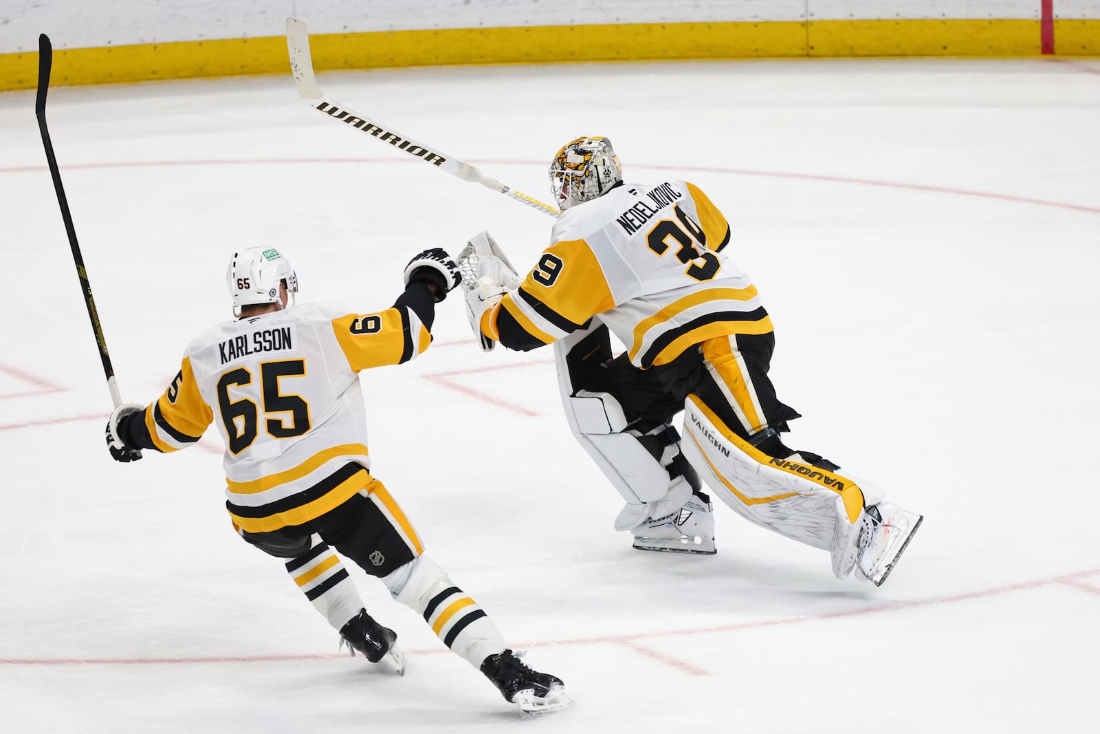 Pittsburgh Penguins goaltender Alex Nedeljkovic (39) celebrates with defenseman Erik Karlsson (65) after scoring during the third period of an NHL hockey game against the Buffalo Sabres, Friday, Jan. 17, 2025, in Buffalo, N.Y. (AP Photo/Jeffrey T. Barnes)