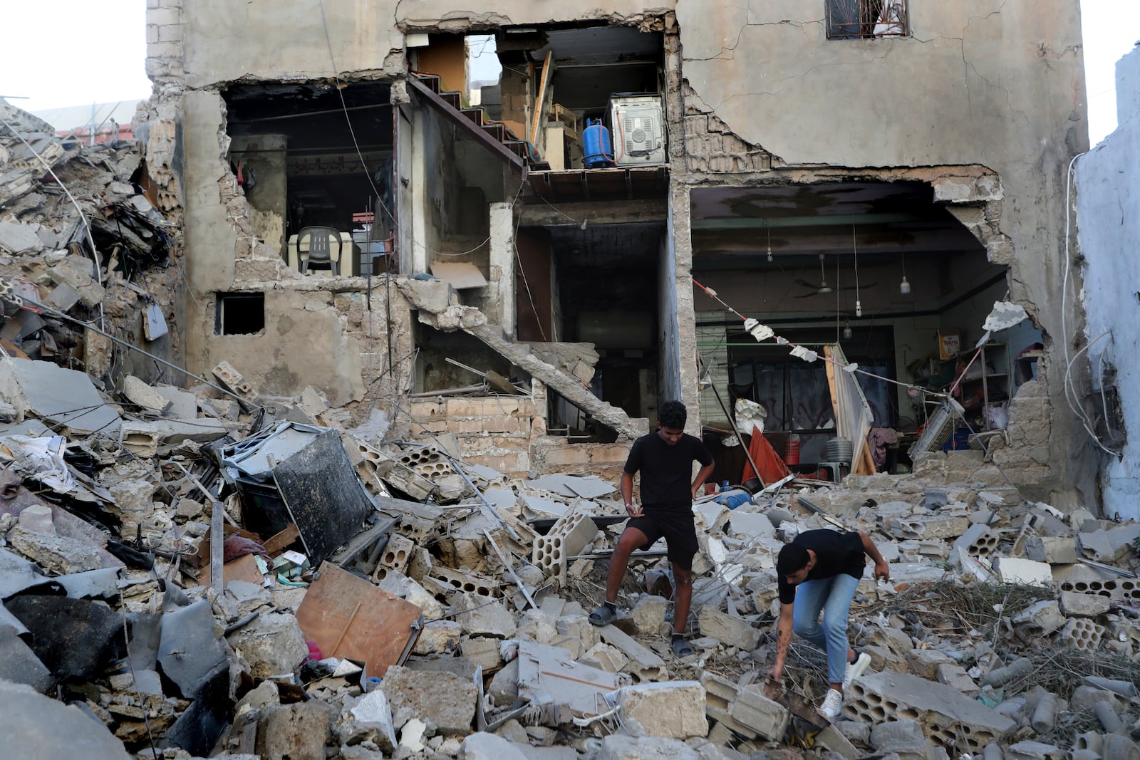 A man searches through the rubble of a destroyed building hit by an Israeli airstrike in Tyre, south Lebanon, Wednesday, Oct. 23, 2024. (AP Photo/Mohammed Zaatari)