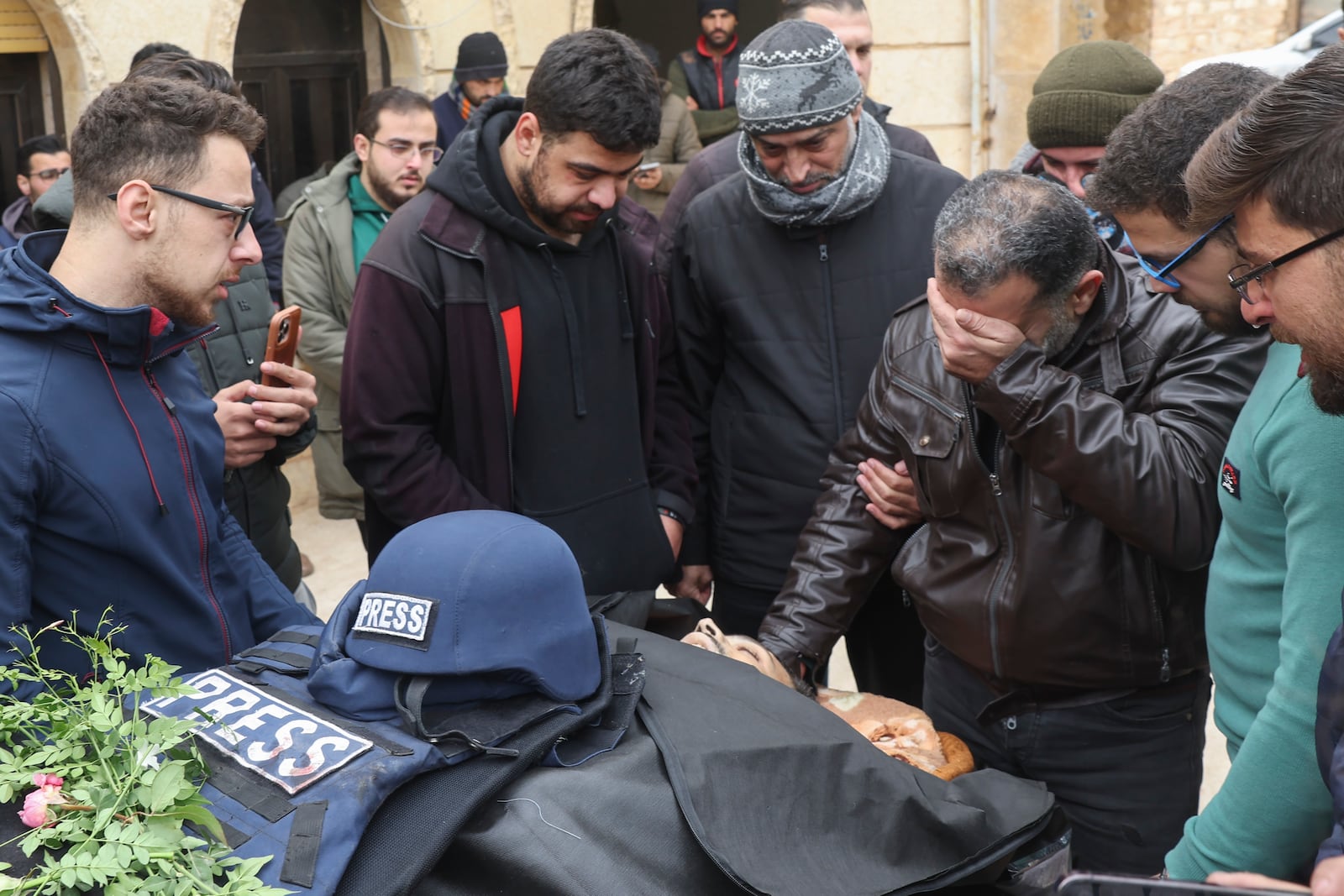 Colleagues and friends mourn over the body of Syrian photographer Anas Alkharboutli, 32, in Idlib, Syria, Wednesday Dec. 4, 2024. Alkharboutli, working for the German news agency DPA was killed in an airstrike near the city of Hama, the agency said Wednesday.(AP Photo/Ghaith Alsayed)