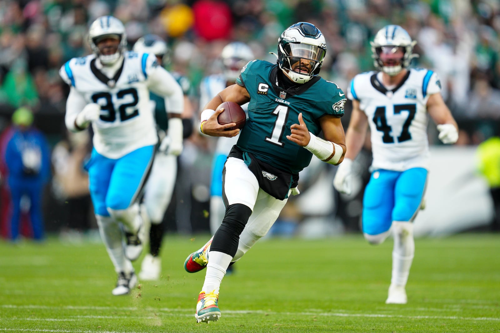 Philadelphia Eagles quarterback Jalen Hurts (1) runs with the ball as Carolina Panthers cornerback Lonnie Johnson Jr. (32) and linebacker Josey Jewell (47) trail behind during the second half of an NFL football game Sunday, Dec. 8, 2024, in Philadelphia. (AP Photo/Derik Hamilton)