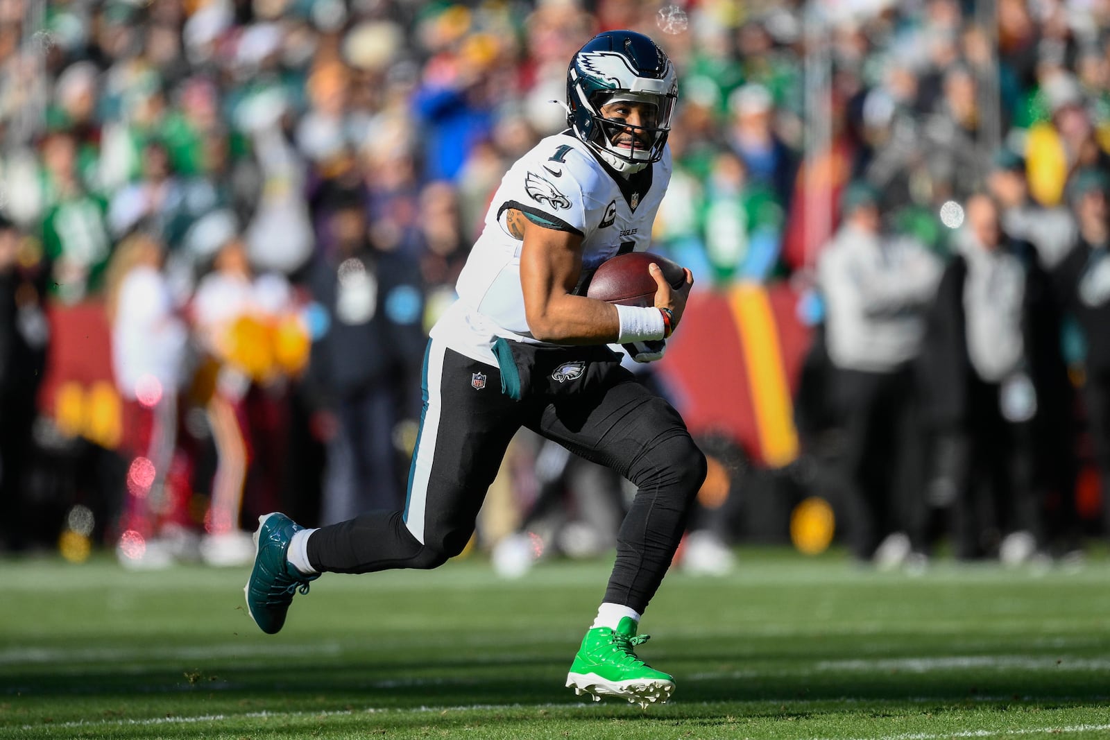 Philadelphia Eagles quarterback Jalen Hurts (1) running with the ball during the first half of an NFL football game against the Washington Commanders, Sunday, Dec. 22, 2024, in Landover, Md. (AP Photo/Nick Wass)