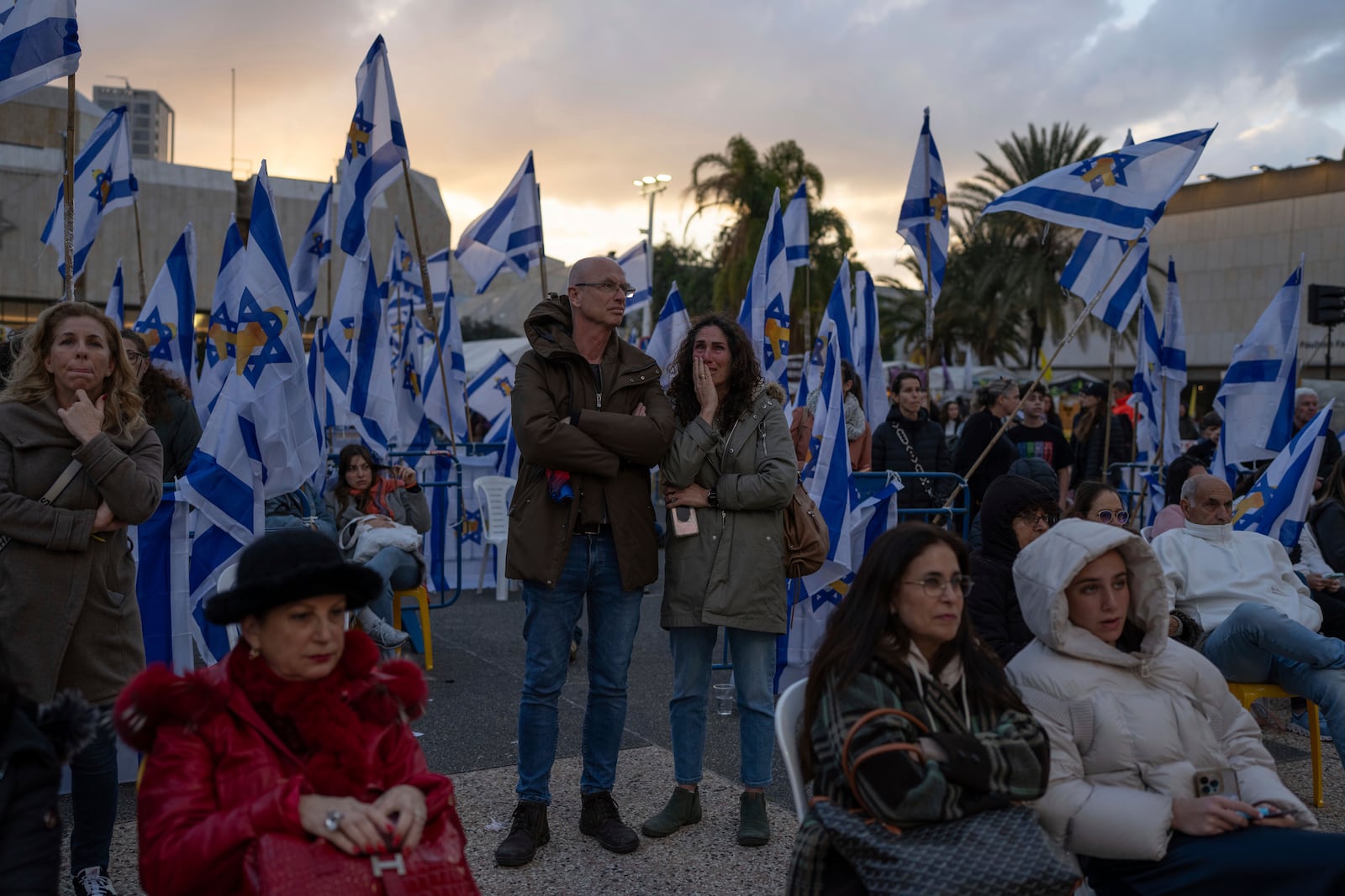 People gather during a vigil hours after the bodies of four Israeli hostages, Shiri Bibas, her two children, Ariel and Kfir, and Oded Lifshitz were handed over by Palestinian militant groups in Gaza to Israel, in Tel Aviv, Thursday, Feb. 20, 2025. (AP Photo/Ohad Zwigenberg)