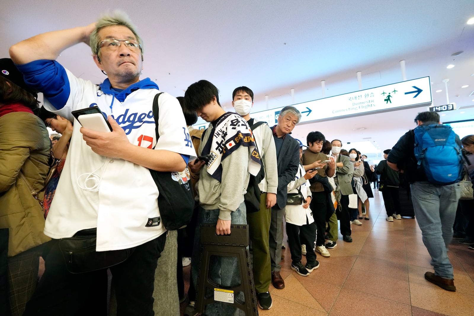 Fans of Los Angeles Dodgers wait for the team arrival at Tokyo International Airport Thursday, March 13, 2025, in Tokyo, as Los Angeles Dodgers is scheduled to play their MLB opening games against Chicago Cubs in Tokyo on March 18-19. (AP Photo/Hiro Komae)