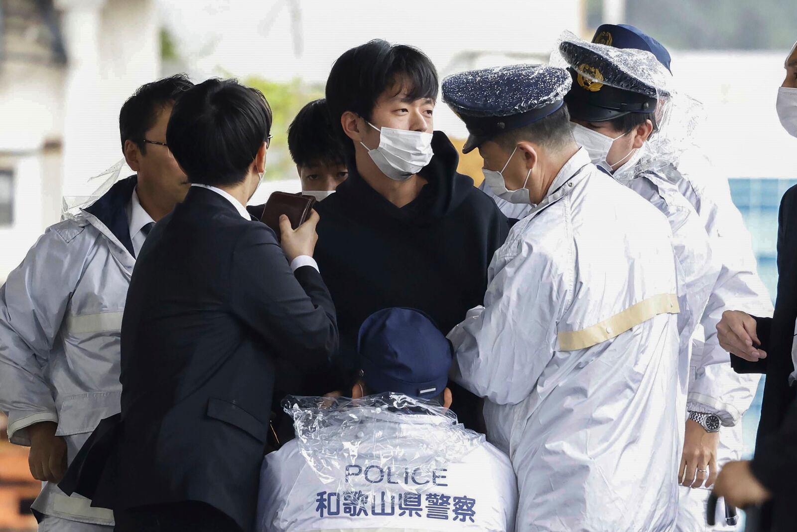 Ryuji Kimura, center, is caught by police after he threw a homemade pipe bomb at Japan's former Prime Minister Fumio Kishida during a campaign event at a fishing port in Wakayama, western Japan, on April 15, 2023. (Kyodo News via AP)