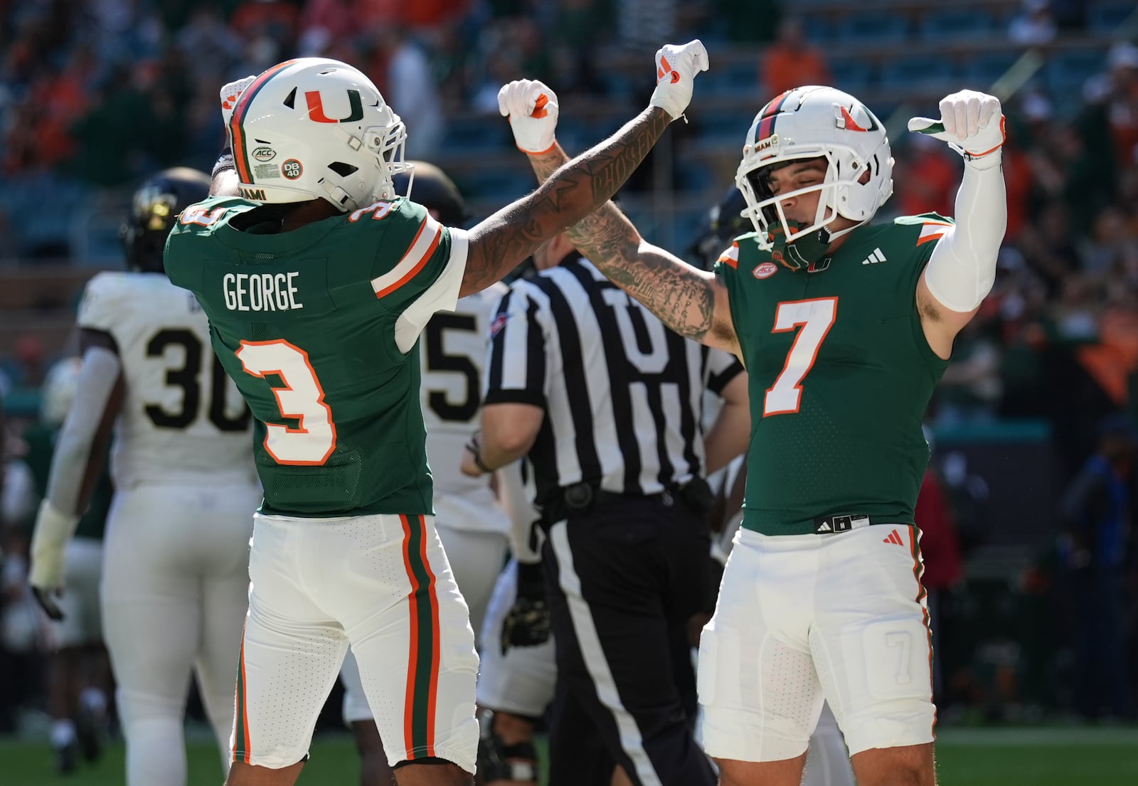 Miami wide receiver Jacolby George (3) celebrates with wide receiver Xavier Restrepo (7) after scoring a touchdown during the first half of an NCAA college football game against against Wake Forest, Saturday, Nov. 23, 2024, in Miami Gardens, Fla. (AP Photo/Lynne Sladky)