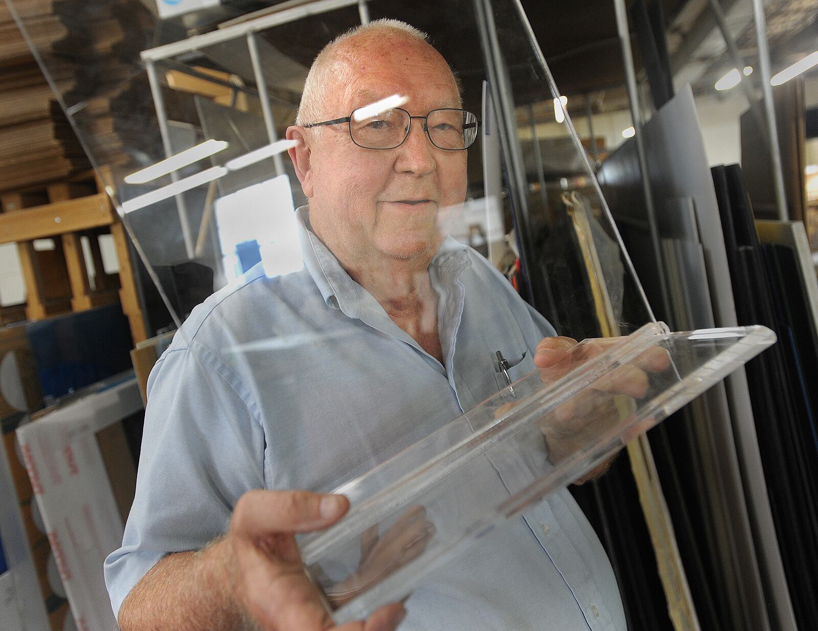 Bernard Kohlberg, CEO, of Kohlfab Custom Plastic Fabrication, shows one of many plexiglass barriers that his company makes. MARSHALL GORBY\STAFF