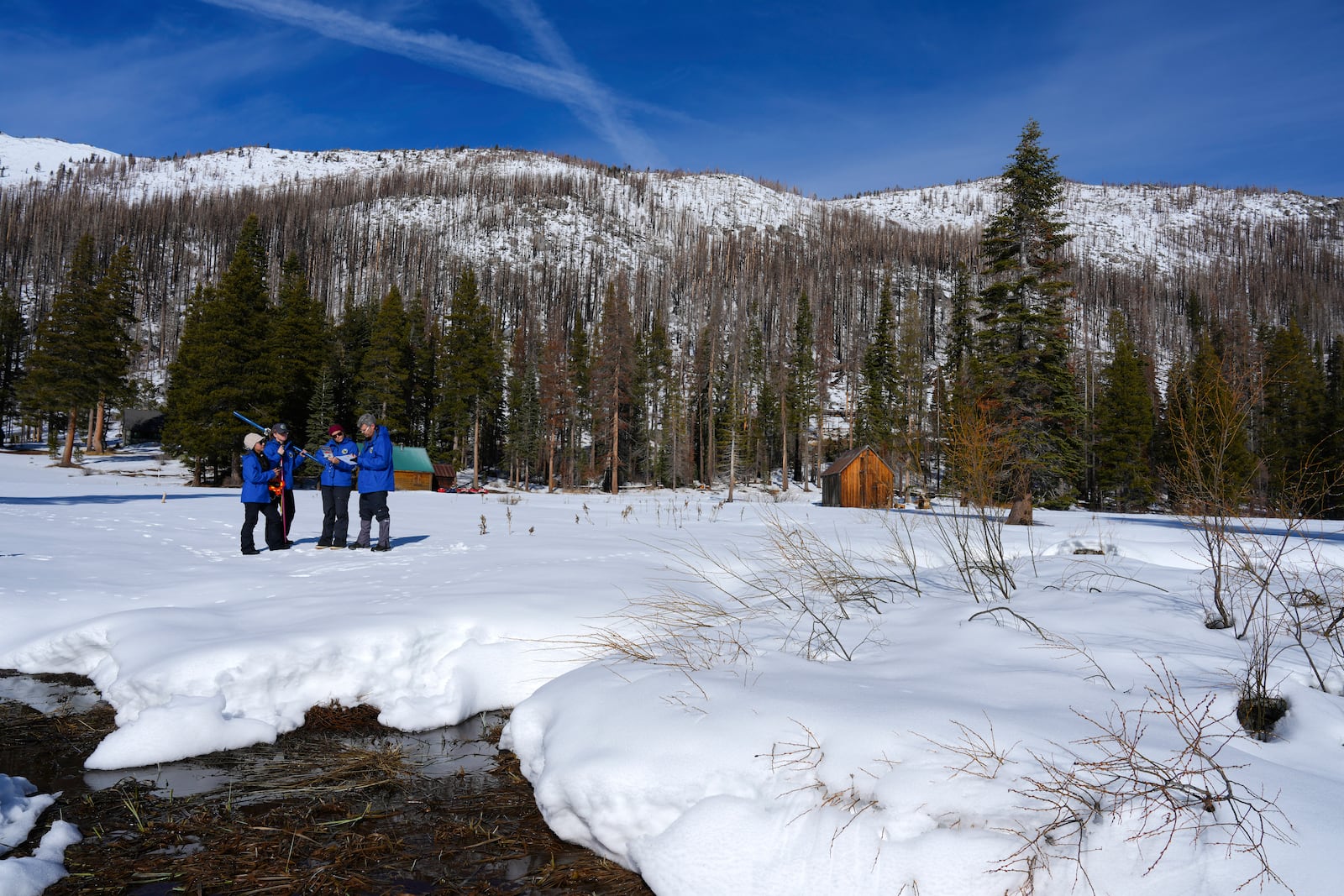 From the California Department of Water Resources, left to right, Angelique Fabbiani-Leon, Jordan Thoennes, Manon von Kaenel, and Andy Reising conduct the first snow survey of the season to assess how much water the state might have come spring and summer at Phillips Station on Thursday, Jan. 2, 2025. (AP Photo/Brooke Hess-Homeier)