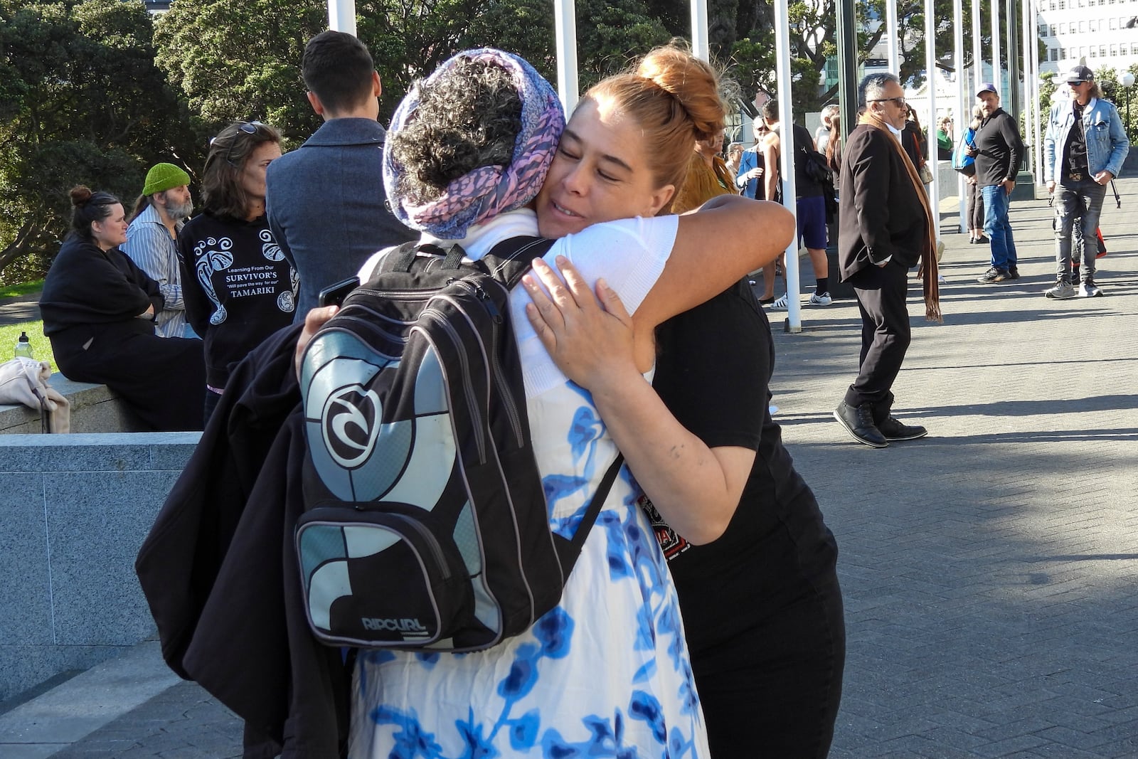 Two women embrace as they arrive at Parliament House in Wellington, New Zealand, ahead of the apology to the survivors of abuse in state, faith-based and foster care over a period of seven decades, Tuesday, Nov. 12, 2024. (AP Photo/Charlotte Graham-McLay )