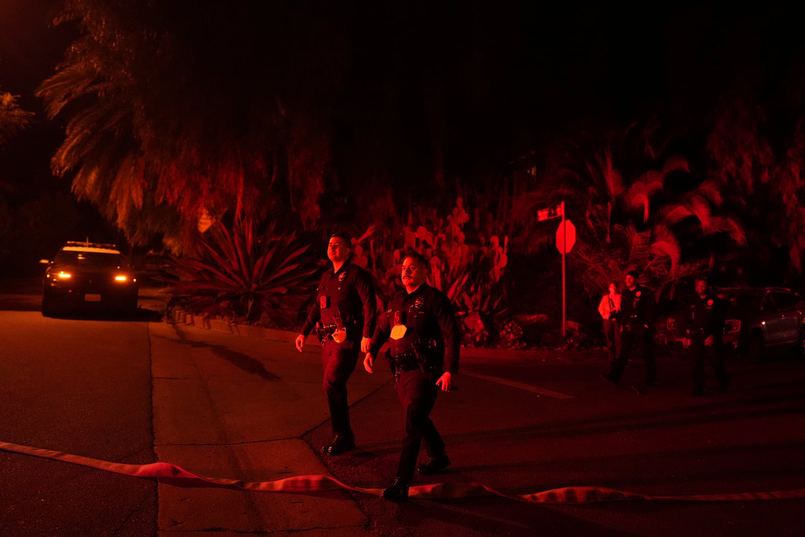 Police officers check on homes to evacuate residents in Mandeville Canyon, Friday, Jan. 10, 2025, in Los Angeles. (AP Photo/Eric Thayer)