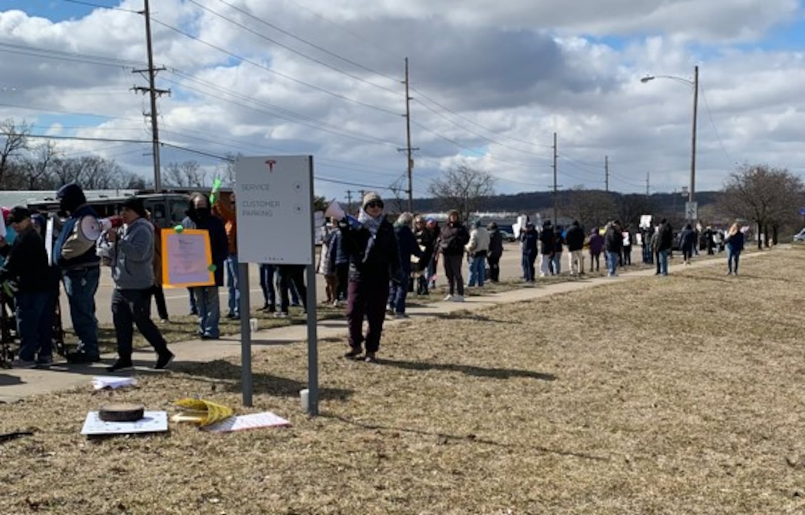 Hundreds of people lined West Dorothy Lane in Moraine on Saturday, March 1, 2025 to protest near a Tesla Service Center. The protest was aimed at Elon Musk, the world's richest man, and his actions with the Trump administration and the Department of Government Efficiency. BROOKE SPURLOCK/STAFF