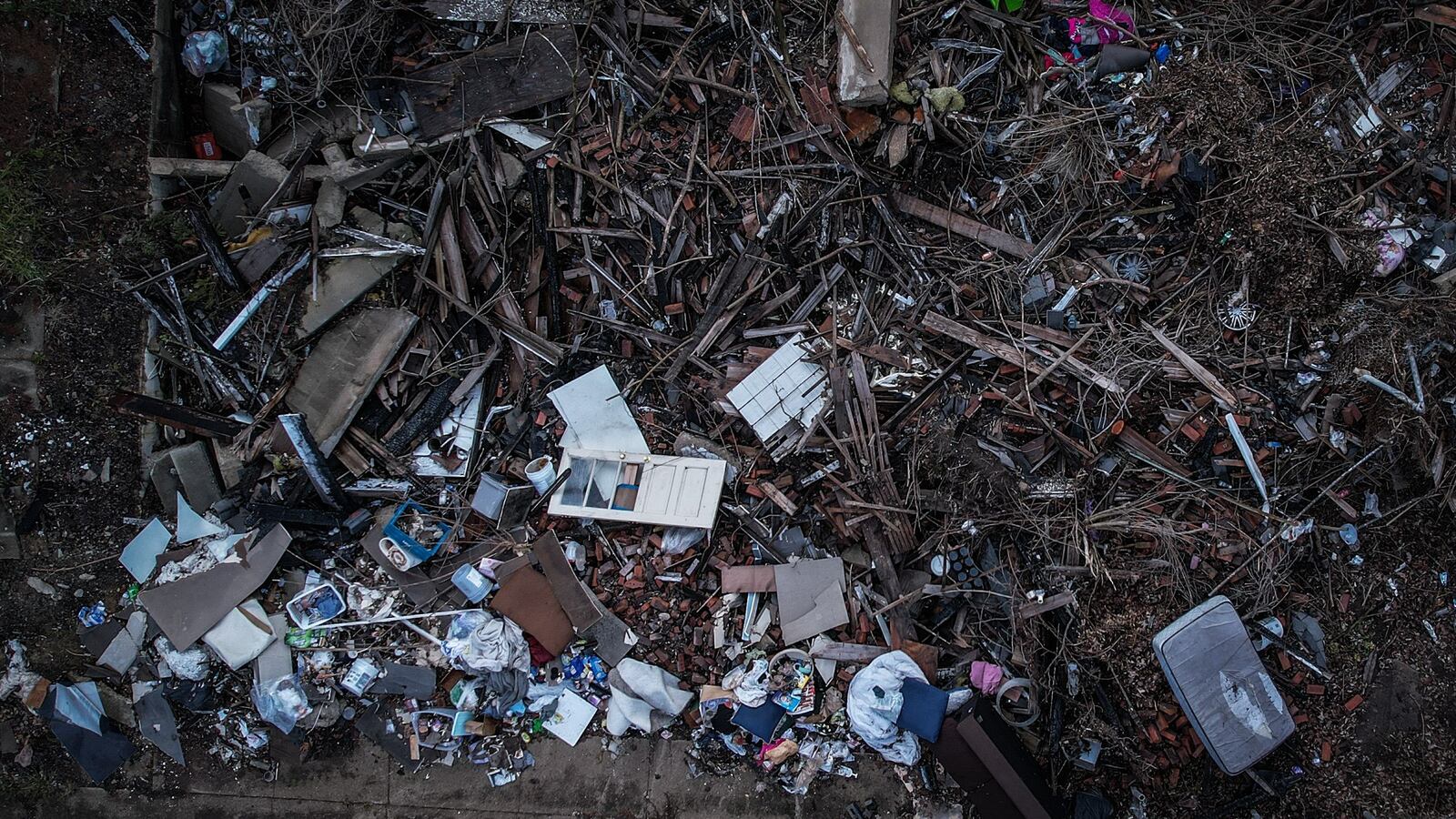 This home on Lorenz Ave. in Dayton burned down last year. The house was demolished but the debris was not removed. The site has attracted illegal dumping. JIM NOELKER/STAFF