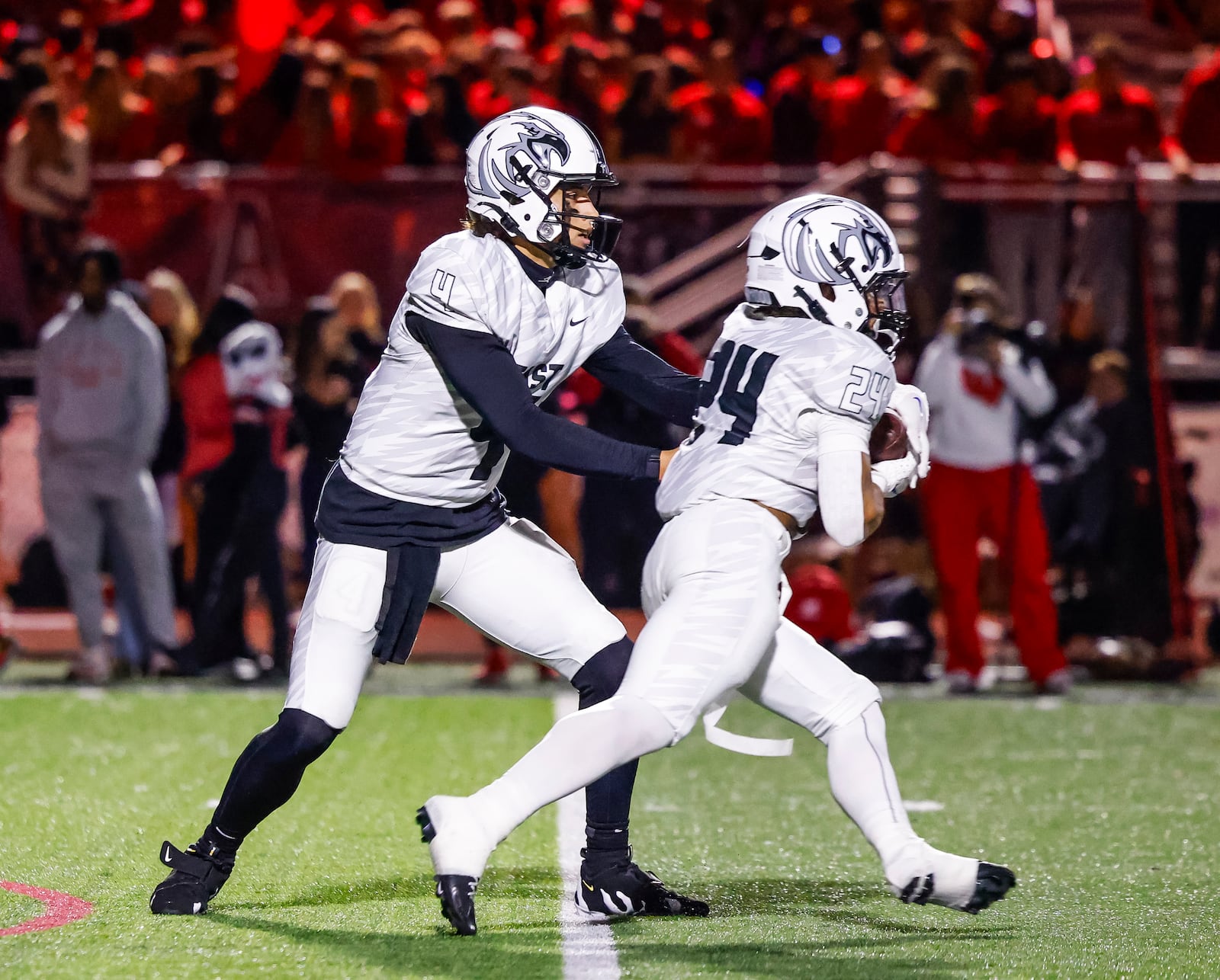 Lakota East quarterback Jamison Kitna hands the ball off to running back Ryder Hooks during their football game against Lakota West Friday, Oct. 18, 2024 at Lakota West High School in West Chester Township. Lakota West Won 42-24. NICK GRAHAM/STAFF