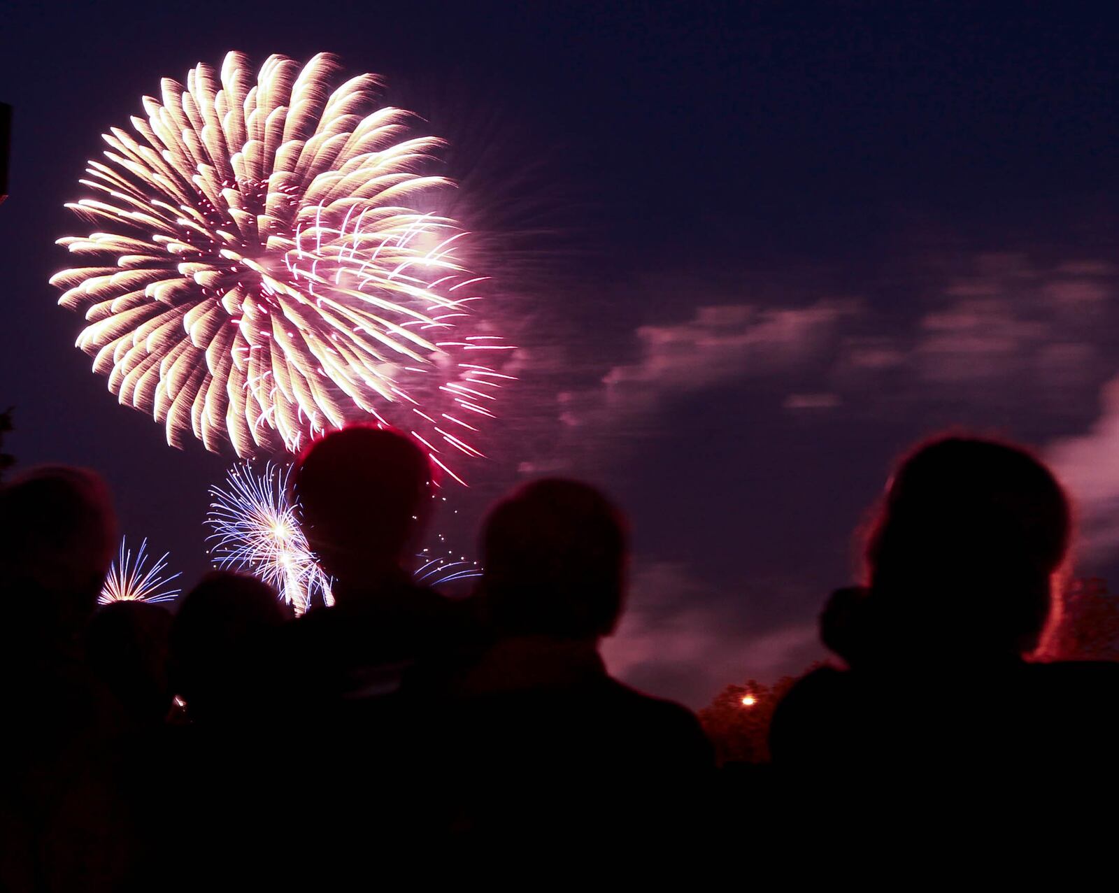 A crowd watches the downtown Dayton fireworks show over Riverscape MetroPark from the vantage point of the Dayton Art Institute. JIM WITMER / STAFF