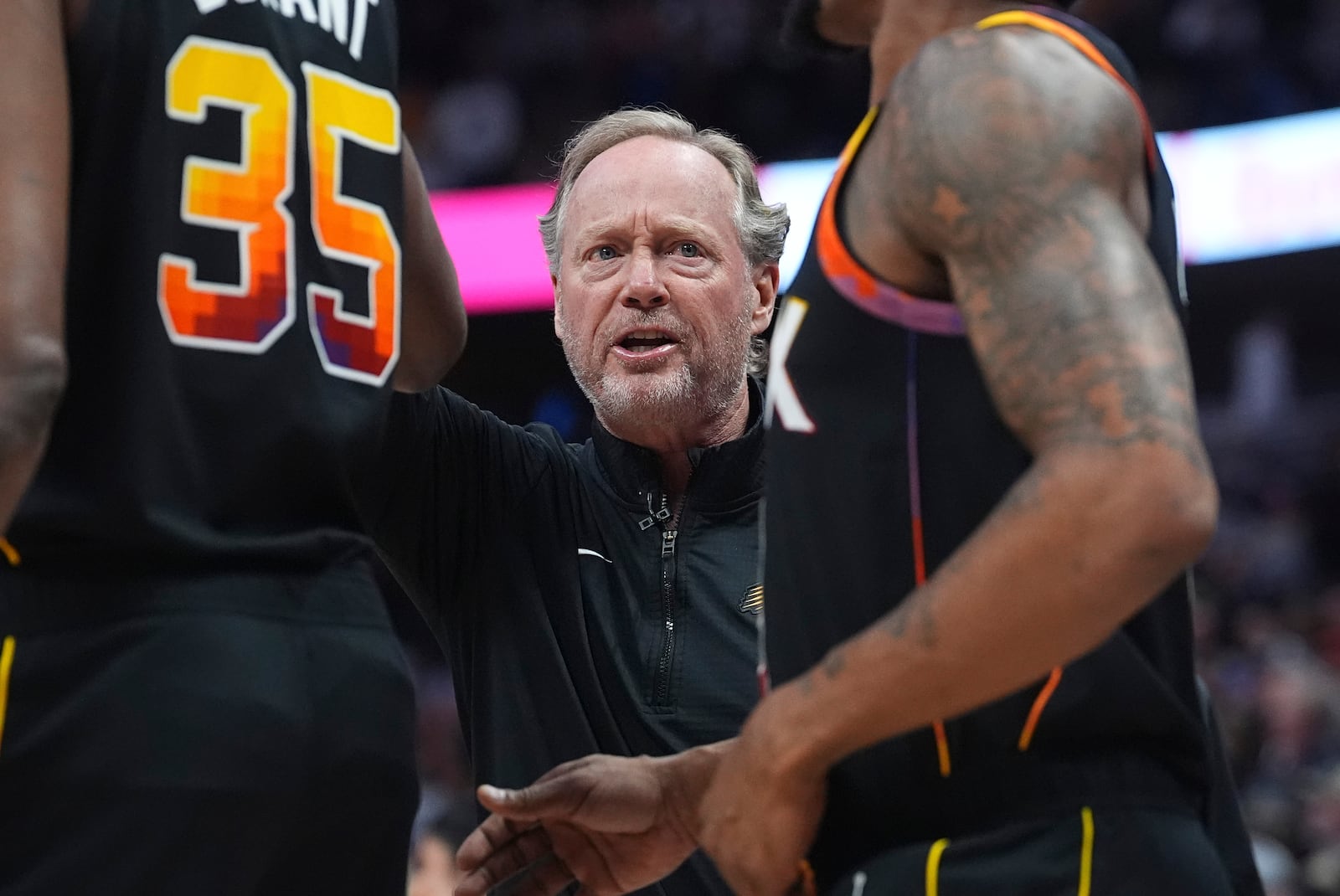 Phoenix Suns head coach Mike Budenholzer directs his team during a timeout in the first half of an NBA basketball game against the Denver Nuggets, Friday, March 7, 2025, in Denver. (AP Photo/David Zalubowski)