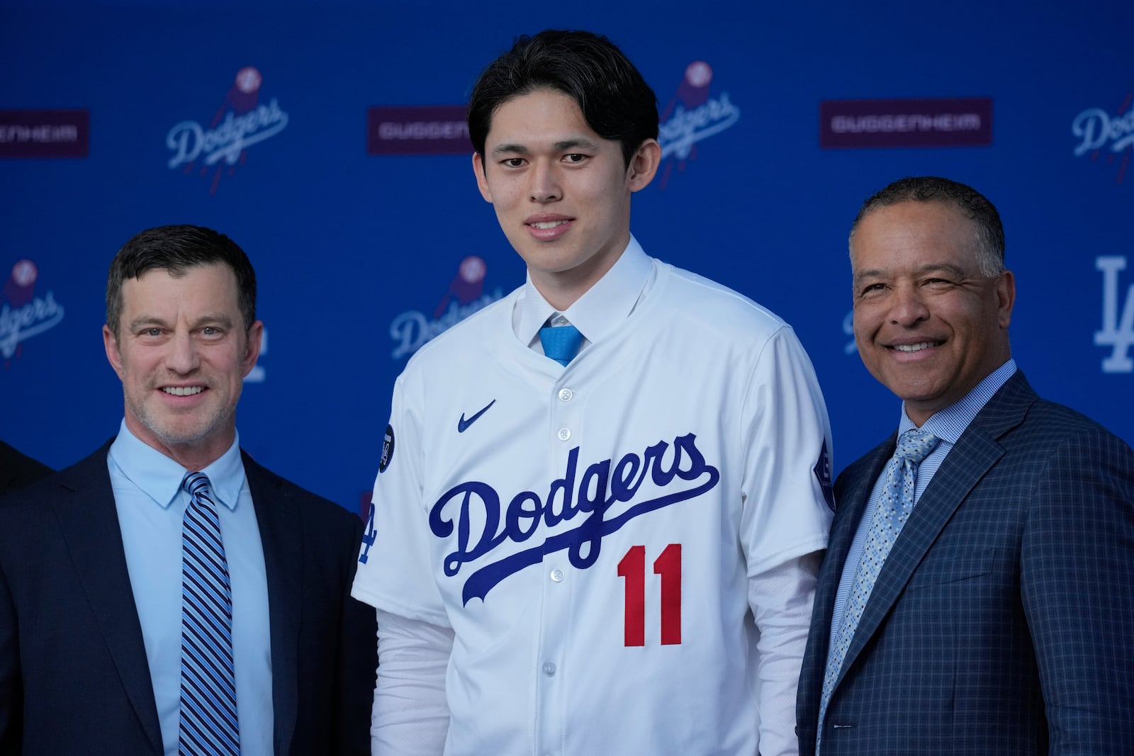 Japanese right-hander pitcher Roki Sasaki, 23, poses with Los Angeles Dodgers president of baseball operations Andrew Friedman, left, and manager Dave Roberts as he is introduced by the Los Angeles Dodgers at a news conference at Dodger Stadium Wednesday, Jan. 22, 2025 in Los Angeles. (AP Photo/Damian Dovarganes)