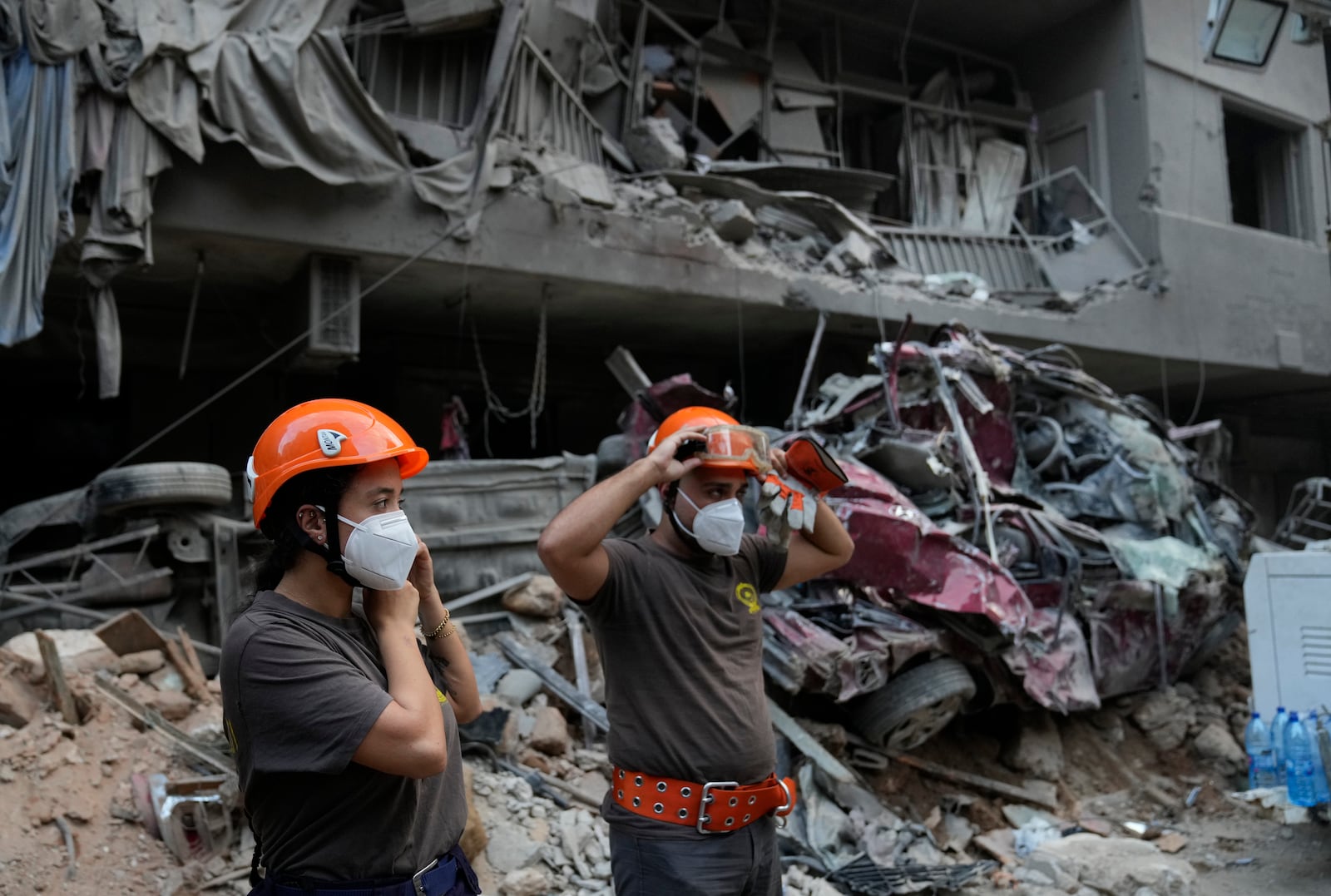 Rescue workers stand in front of destroyed buildings, as they prepare to start search for victims at the site of Thursday's Israeli airstrike, in Beirut, Lebanon, Friday, Oct. 11, 2024. (AP Photo/Hussein Malla)