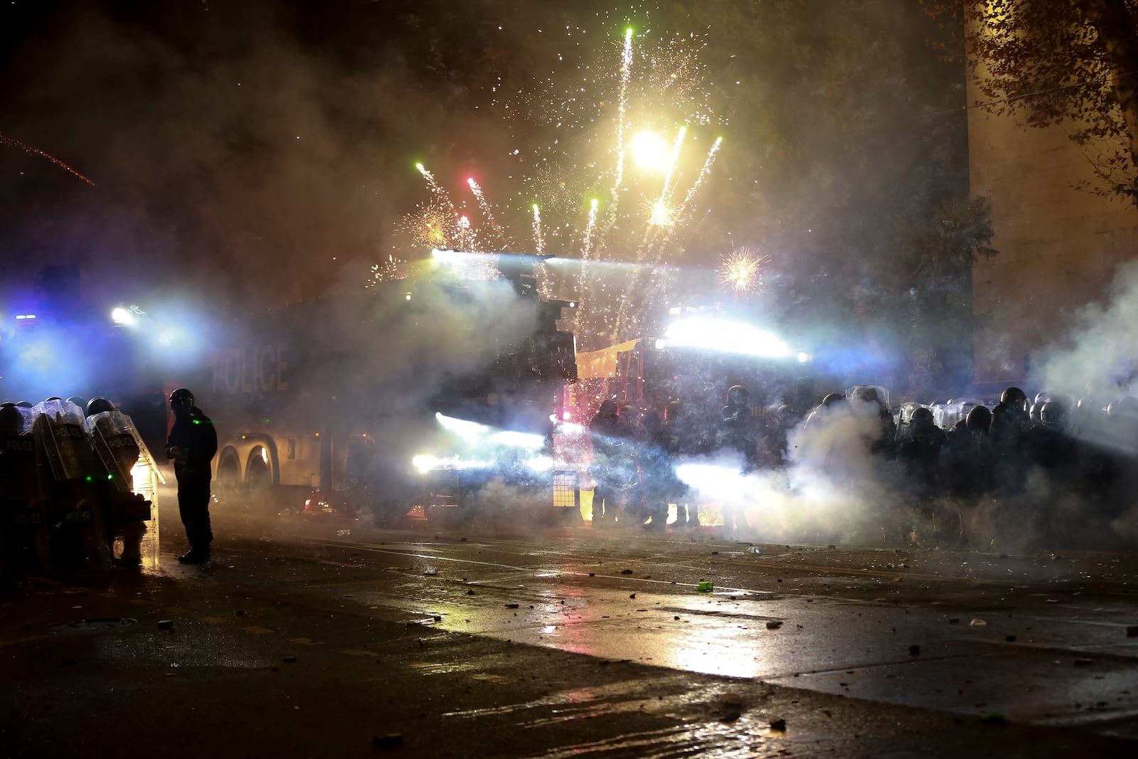 Demonstrators use petard against police as police blocked a street to prevent protesters rallying against the governments' decision to suspend negotiations on joining the European Union for four years, outside the parliament's building in Tbilisi, Georgia, early Saturday, Nov. 30, 2024. (AP Photo/Zurab Tsertsvadze)