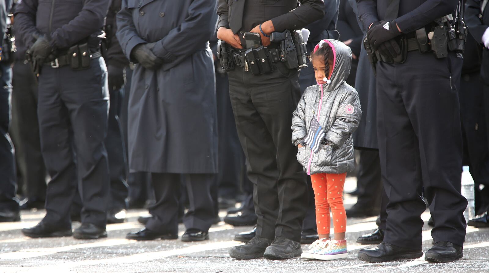 A child stood with police officers from Union City during the honor service held after funeral services for Dayton Police Detective Jorge Del Rio Tuesday at the University of Dayton Arena. LISA POWELL / STAFF