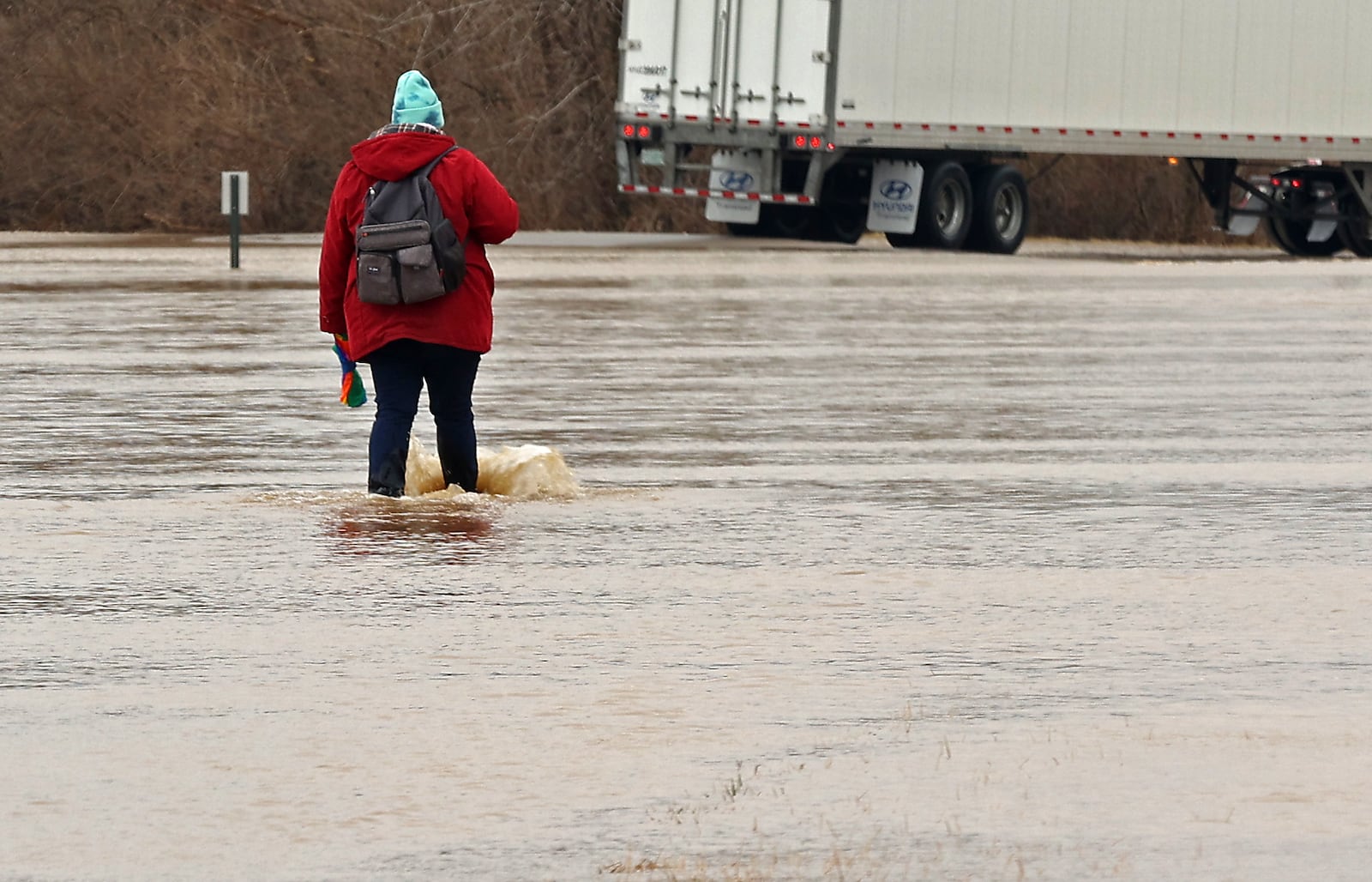 A woman wades through the flood water that covered St. Paris Pike in Clark County Monday following an overnight storm. BILL LACKEY/STAFF